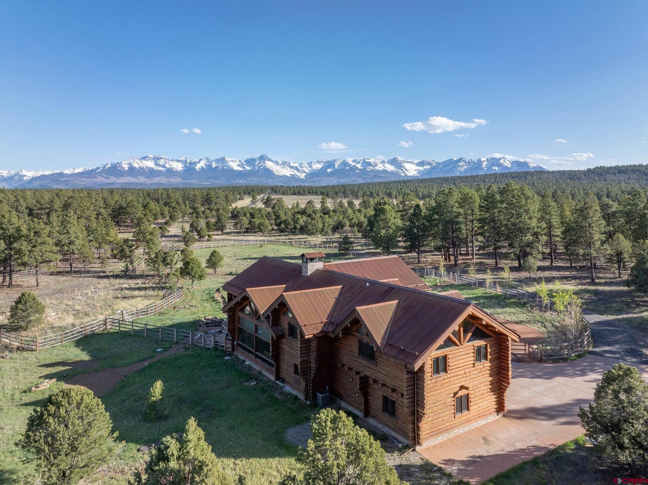 Welcome to Stagecoach Lodge, a stunning and ultra private 35-acre luxury retreat perched atop Log Hill Mesa in beautiful Ridgway, Colorado. This spectacular log cabin estate offers unmatched panoramic views of the Sneffels Range and the Cimarrons — a rare vantage point that perfectly captures the magic of the San Juans. Spanning 4,760 square feet, the 4-bedroom, 3.5-bathroom home masterfully blends rustic elegance with modern comfort. The open-concept living spaces feature soaring ceilings, massive log beams, and walls of glass that bring the breathtaking mountain vistas and sunlight right into your home.  Designed for both entertaining and peaceful retreat, the property includes expansive outdoor living areas, perfect for soaking in the hot tub under starry skies, gathering with friends and family, or hosting unforgettable events.  The gourmet kitchen, spacious bedrooms, and spa-style bathrooms offer all the luxuries of a high-end mountain escape. A fully equipped solar system adds energy efficiency, while the oversized garage and workshop space cater to any hobby or adventure gear needs. Horse lovers will appreciate the equestrian setup, making this a true Colorado lifestyle property.  Whether you're looking for a private sanctuary or a top-performing investment, Stagecoach Lodge delivers. With a strong rental history and high occupancy rates, this property generates significant income as a premium short-term rental, offering an exceptional opportunity for both enjoyment and return on investment.  Memories made in the mountains will be abundant at this luxury lifestyle home with the Divide Ranch and Golf course just down the street, horseback riding, hiking, biking, jeeping, fishing, climbing, hot springs, the Million Dollar Highway, eateries, watering holes, and shops all at your fingertips!