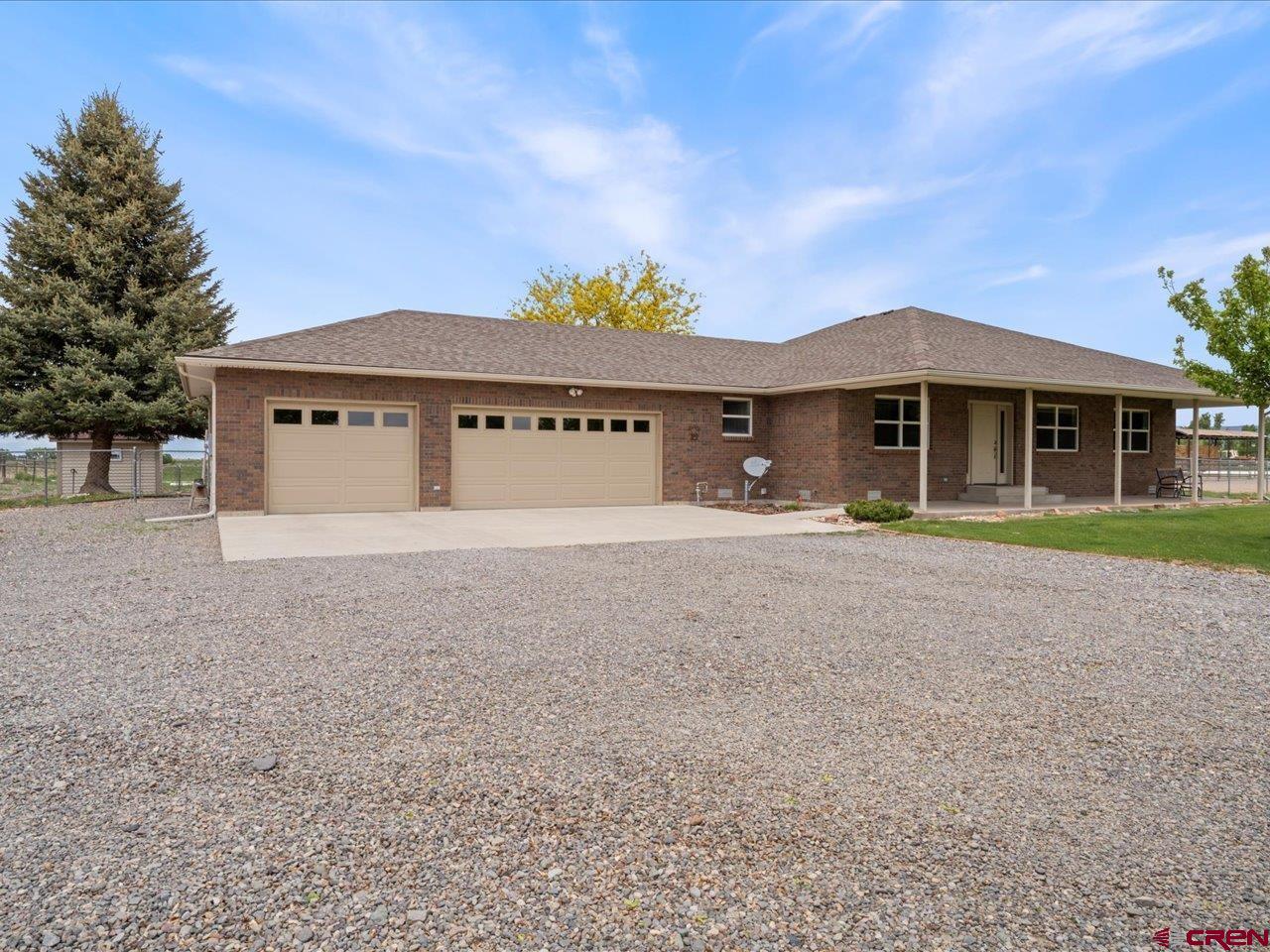 Welcome to this beautifully crafted all-brick home that blends modern comfort with rural charm. Situated on a serene and fully usable 10.00 acre property, this exceptional estate is thoughtfully designed for both luxurious living and versatile functionality.  Enjoy energy-efficient geothermal heating and cooling along with a gas fireplace in the living room.  There are irrigation water shares for the pasture/field plus a shallow well for maintaining the shrubs and lawn.  The spacious garage includes an EV charger, perfect for environmentally conscious living.  Equestrian and livestock enthusiasts will appreciate the 4 stall Morton livestock shelter featuring three stalls with metal pipe runs, water and electric service, as well as an arena. There is also a +/- 1,200 sq.ft. building that houses an insulated and heated workshop with electric and water services and equipment storage area for all your projects and tools.  Outdoors, the property offers a large, covered patio ideal for entertaining or quiet evenings, and a heated doghouse that ensures comfort for your canine companions year-round. Whether you're looking for a peaceful homestead, a hobby farm, or an equestrian haven, this property has it all—style, substance, and space to thrive.
