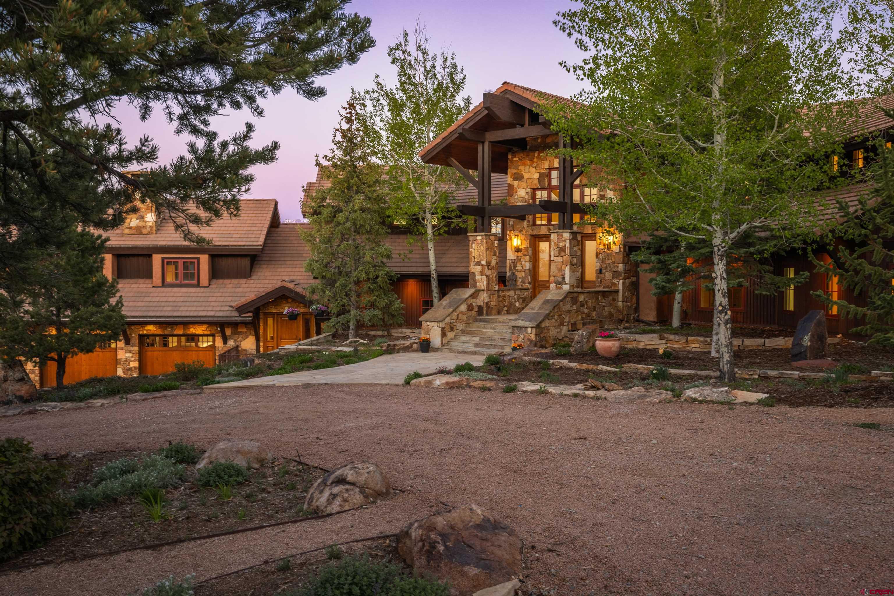 A Fully Remodeled Modern Mountain Estate on 5.78+ Private Acres. This exceptional multi-generational home underwent a complete transformation in 2025, elevated into a modern, mountain luxury home—offering timeless elegance and contemporary comfort throughout with the perfect balance between entertaining spaces, everyday living, and grandeur. Located at the end of a quiet cul-de-sac, this home offers panoramic views of both the San Juan and Cimarron Mountain Ranges, with the privacy and serenity of 5.78+ acres. Originally designed by famed architect Lee Anne Schmidt, the main home features 4 bedrooms and 3.5 baths, while the attached guest quarters offer 2 additional bedrooms and 2 bathrooms, complete with their own private entrance and a real wood-burning fireplace. Every aspect of the home was updated in 2025—from finishes to systems—to provide a fresh, modern aesthetic while preserving its architectural integrity. Inside, the kitchen was completely updated, and a walk-in pantry was added along with all new Wolf and Sub-Zero appliances and a massive functional island! Over 6.5 tons of HVAC capacity was added with the installation of mini-splits throughout. The main level includes the expansive kitchen with multiple dining options, primary suite(updated), guest bath(updated), and several large decks (including one with an outdoor shower), all re-stained. Splendid views are captured from nearly every window. The primary suite boasts 2 large walk-in closets, an updated bathroom with modern shower controls, a new modern fireplace, and a private deck reinforced and wired for an additional hot tub. The lower level offers a luxury game room, a stylish bar, and a media room(updated), along with several guest bedrooms(updated) and an additional laundry area. The guest quarters were also remodeled and self-contained, and can serve as a lock-off residence. One suite features a rainfall shower and bathtub; the other includes a walk-in shower. The attached 3-car garage includes an exercise room and easy-to-clean vortex spray liner flooring. Outdoor amenities include a 6-person hot tub, multiple decks and patios, entertainment areas, and a large greenhouse for year-round gardening or flex space. A low-maintenance concrete tile roof and an 18KW grid-tied solar system offer both style and sustainability. Fire mitigation work was completed along the fence around the home in addition to the entire 5-plus-acre lot. The security system has been augmented with state-of-the-art cameras, gate controllers, and connection points offering tremendous peace of mind. with your dream home secured, additionally be a large gate and high fence. This "end-of-the-road" sanctuary offers the rare combination of complete privacy and accessibility. Why build new when you can own a fully modernized masterpiece ready for immediate enjoyment? This is one home you need to see!