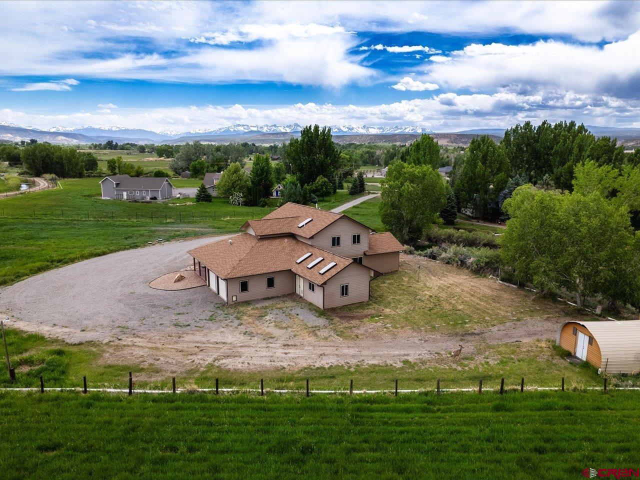 Come home to this beautiful irrigated property on 11.5+ acres just south of Montrose featuring beautiful views of the mountains.  This is the perfect property for a hobby farm, to raise livestock and grow plenty of hay with irrigation infrastructure in place and included. Step inside to this 2695 square foot newly painted home boasting a large covered deck. It has an open kitchen and living room area with vaulted ceiling, a large primary suite on the main level, and new waterproof vinyl flooring throughout. The main level also features an additional bedroom or office, laundry room and large finished attached shop area. Upstairs you will find a great office or crafting space, two additional bedrooms and full bathroom. Attached is also a large two car garage. A new Geothermal heating and air system has been installed with a circulating pump to make utilities very efficient. While you take in the beautiful views outside you will notice the ease of irrigating with more than enough irrigation water, and a large open space yard to allow all your landscaping and gardening ideas with even a good sized shed. This property is sure not to last long, come see it today!
