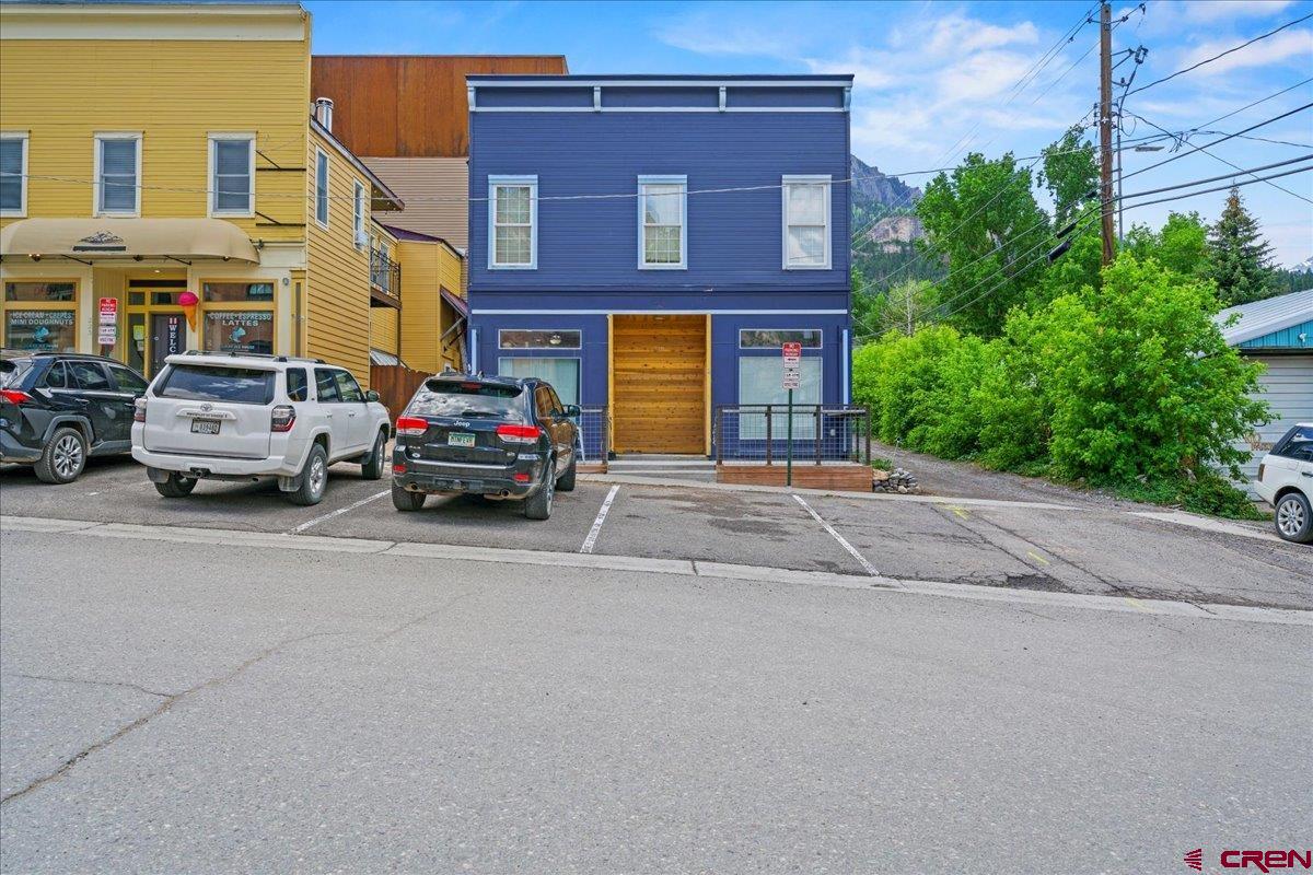 Great commercial mixed-use/residential property located in the heart of beautiful downtown Ouray—also known as the "Switzerland of America!" This could be the perfect opportunity for a live/work situation. The building includes a total of four units. The spacious upstairs apartment features two bedrooms and two bathrooms, an open kitchen/living area with large windows, and stunning views. This unit also offers a generous laundry room, a walk-in closet in the primary bedroom, and a lovely private deck. Downstairs, there are two additional one-bedroom, one-bath apartments, along with a commercial space currently home to a charming hair salon. The front deck showcases amazing views of Cascade Falls and the surrounding mountains.  Please note: No FF&E is included in the sale of the property. A 24-hour notice is required for all showings.
