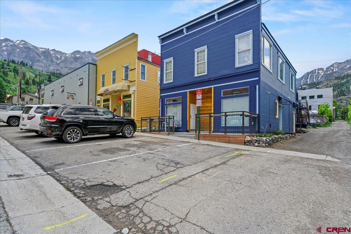 Great commercial mixed-use/residential property located in the heart of beautiful downtown Ouray—also known as the "Switzerland of America!" This could be the perfect opportunity for a live/work situation. The building includes a total of four units. The spacious upstairs apartment features two bedrooms and two bathrooms, an open kitchen/living area with large windows, and stunning views. This unit also offers a generous laundry room, a walk-in closet in the primary bedroom, and a lovely private deck. Downstairs, there are two additional one-bedroom, one-bath apartments, along with a commercial space currently home to a charming hair salon. The front deck showcases amazing views of Cascade Falls and the surrounding mountains.  Please note: No FF&E is included in the sale of the property. A 24-hour notice is required for all showings.