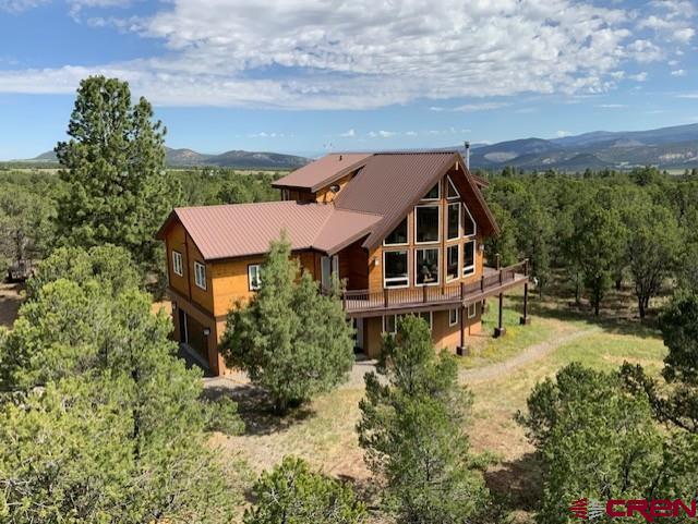 Tucked away on a quiet, low-traffic cul-de-sac, this 5-acre sanctuary borders protected open space and offers views of the San Juan Mountains and Cimarron Range. Located on Ridgway’s highly desirable Log Hill Mesa, the property delivers rare privacy, abundant wildlife, and access to nearby hiking and nature trails. The open floor plan cedar 3-bedroom + flex room, 3-bathroom home was thoughtfully positioned for optimal sun exposure and unobstructed views, with soaring vaulted ceilings, large picture windows, and multiple outdoor living spaces including a spacious deck—perfect for soaking in the alpenglow or spotting local wildlife like  deer, foxes, and hawks. Interior features include in-floor radiant heat, a cozy wood-burning stove, hunter ceiling fans throughout, and a whole-house fan for energy efficiency. The bonus flex space adds versatility for a home office, gym, workshop or guest suite. The oversized 2-car garage offers excellent storage and workspace. With access to highspeed fiber optic to the property this home is ideal for remote work or year-round living. All just 15 minutes to Ridgway, 30 minutes to Montrose, and 60 minutes to Telluride for skiing, festivals, and fine dining.