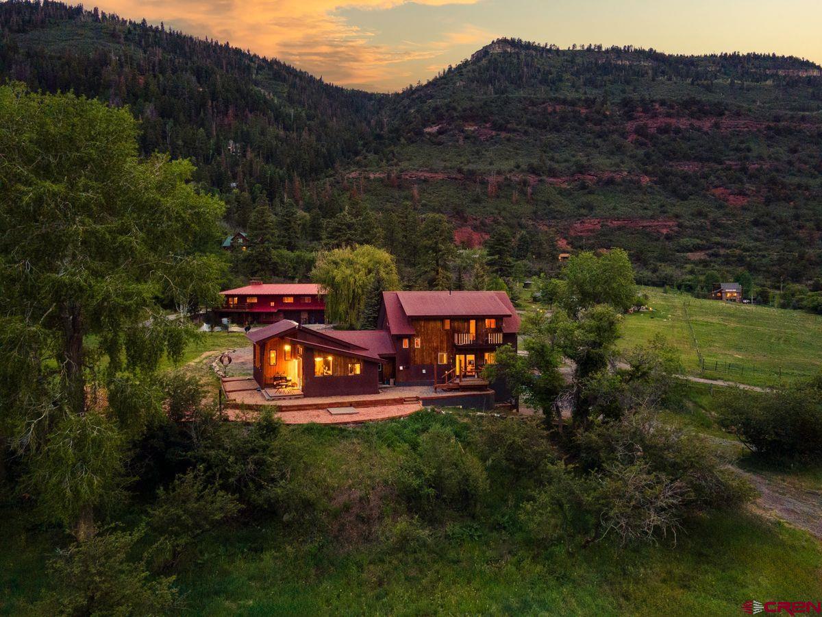 An intimate setting in the Ouray Valley featuring a custom home on a verdant site, with fenced pasture and room to expand. The 3-bed/3.5-bath residence on 5.8 acres offers its next owner a wide range of options. Highlighted by an open great room - anchored by a chef-designed kitchen - the home's living spaces were inspired by a desire to gather with friends and family. The primary suite has a private deck and walk-in closet. Main floor suite has a common room, kitchen, and separate entrance options. Third bedroom and flex space have a dedicated bath on the top level. Home has an oversized 2-car garage, tiered landscaping, established garden, an RV pad with hook ups, and existing access to ag water to create anything from an orchard to a horse farm. A slice of paradise to make your own.