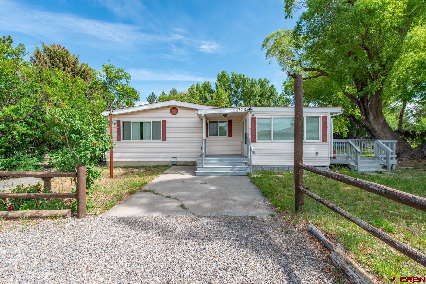 Discover this truly unique property that blends rural tranquility with versatile living and tons of potential. Situated in Montrose city limits on 1.486 acres with irrigation, this 3-bedroom, 2-bathroom home offers a thoughtful mix of charm, space, and opportunity. Originally built in 1979 as a manufactured home, the property has been expanded with a spacious approximately 600-square-foot addition—perfect for extra living space, a hobby area, or office. The large addition enhances the home’s footprint, from 1248 to approximately 1648, creating flexible options for your lifestyle needs and 2 covered porches to relax on. Step inside to find a completely remodeled, warm and functional layout featuring a large open kitchen with new appliances, countertops, large center island, and beautiful flooring. This home has 3 comfortable bedrooms, 2 beautiful remodeled bathrooms, and additional rooms for extra living space and office.  Home has been updated with a new gas tankless hot water tank and new heating system. Outside, enjoy country setting with mature trees and plenty of room for gardening, pets, or simply relaxing in your own peaceful setting. There is a massive 1800 sq ft metal shop building with a 3/4 bathroom, 3 separated shop areas - one is currently set up as a large quilting/sewing room, one is a pool table room, and one is a working shop. There are several additional storage areas within the metal shop as well as a large, very sturdy covered carport and a covered work area. There are many sheds and storage areas with tons of room for RV's and toys within a fenced gravel area. Whether you're looking for a quiet escape, a place to make your own, or a base for creative possibilities, this property offers endless potential. Schedule your showing today and come explore the possibilities this unique home has to offer! It is truly one of a kind!!