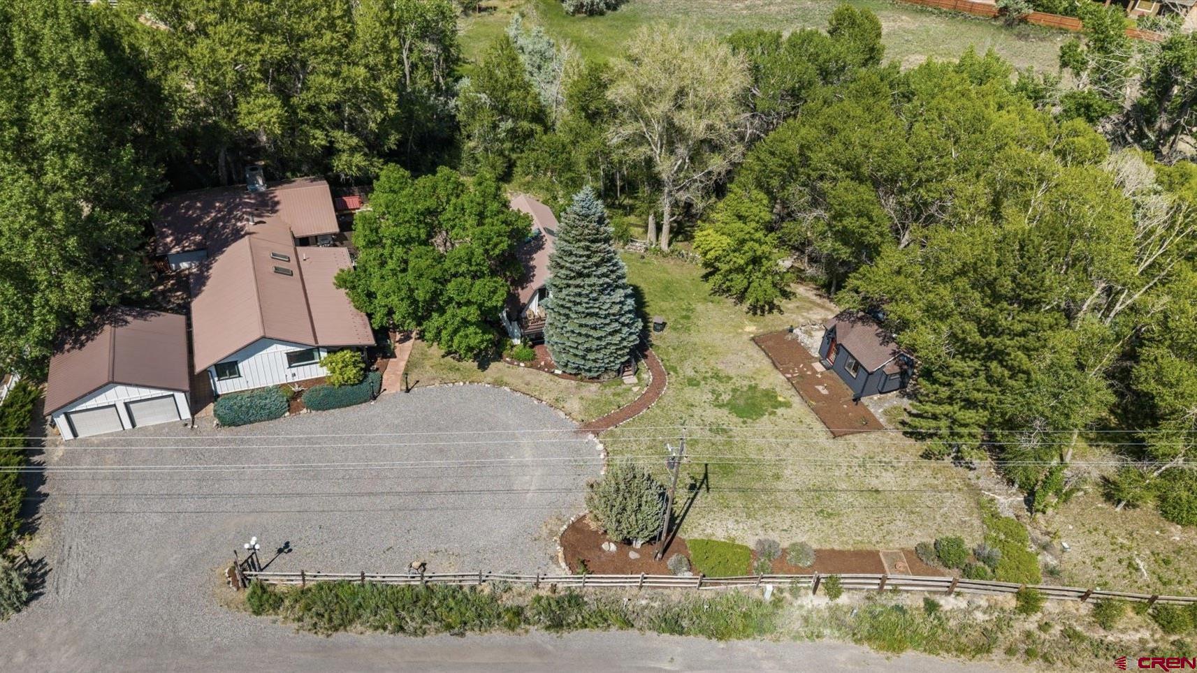 AVAILABLE FOR SHOWINGS AFTER JUNE 19, 2025. Enchanting Retreat with Studio Apartment on 2.19 Acres – No Covenants, Stunning San Juan Views & Successful Airbnb!     Welcome to a hidden gem just outside the city limits—where serene privacy meets timeless charm on 2.19 acres with Southern views of the San Juan Mountains and mature trees that create a private, park-like setting. This unique property offers a lifestyle of comfort, creativity, and income potential, with NO COVENANTS or HOA to restrict your imagination.    The 2,144 sq.ft. main home features arched doorways, a cozy library/sitting room with a wood-burning stove, and a spacious kitchen with center island that opens to a great room with large view windows and direct access to expansive decks. Two private suite bedrooms each include their own bathrooms, one with a  jetted soaking tub and large closet. Major upgrades include a dual AC/furnace system (2024), Forever water heater, new high-end LVP flooring, all new kitchen appliances,  a new front door, gutters, roof upgrades, and a fresh exterior paint job—providing modern comforts with classic style.    The detached 1,400 sq.ft. studio apartment is a game-changer. Currently operating as a highly successful Airbnb, this guest house was fully remodeled in 2023 and is available fully furnished for a true turnkey short-term rental opportunity. The lower level includes a private bedroom, bathroom, and kitchenette with its own water tap, while the upper level—currently used as bonus flex space—offers inspiring mountain views from large windows and a private balcony. Paid blueprints are available  to finish this level as a second rentable unit, with plumbing already in place.    Outside, the property is a haven of relaxation and wonder. Multiple patios, firepit areas, flowers, trails, and decks invite outdoor living. A charming turreted cottage adds character and could be used as a studio, office, or whimsical playhouse. There’s a fenced chicken area, and irrigation water is delivered via a picturesque, meandering channel that flows through the property, connected to the on-site sprinkler system. This property includes a valuable pump right with the Uncompahgre Valley Water Users Association, ensuring efficient seasonal watering for the lush landscape, gardens, and trees—perfect for those dreaming of a mini homestead.    Additional highlights include: • Detached 2-car garage  • Hot tub-ready electrical setup • Security system pre-wired • City utilities: water, sewer, trash • Less than a mile to the local rec center, schools, dining, shopping    Whether you’re seeking multi-generational living, a peaceful home base, or a ready-made investment property with income history, this extraordinary property offers it all. With thousands of dollars in recent upgrades, abundant charm, and flexible use options, this home is truly one-of-a-kind.    Call today to schedule a private tour—come experience the lifestyle you’ve been dreaming of. ***Interior photos of main house, aerials, etc. have been professionally scheduled and will be available 6/19/2025.