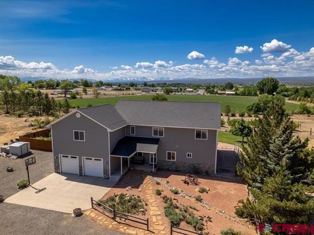 Exceptional Country Living on 44+ Acres – Modern Comfort Meets Rural Charm, beautiful views of the San Juans Discover the perfect blend of space, comfort, and efficiency with this beautifully maintained 3,243 sq. ft. home, nestled on 44.41 acres of serene countryside. Built in 2003 and designed for both practicality and enjoyment, this property offers approximately 40 acres of irrigated land — ideal for hay production, hobby farming, or simply enjoying wide open spaces. Step inside to an updated kitchen that flows seamlessly into inviting living areas. The kitchen is complete with a custom wine/storage cabinet, in cabinet motion activated lighting, granite countertops, and more! Picture yourself waking up every morning in the master bedroom with an incredible mountain view! Upstairs holds two bedrooms, a flex room, a large bathroom complete with a laundry chute, and a spacious family/bonus room. The bonus room can become the ultimate retreat with a mini refrigerator, pool table (included), and access to a private deck — perfect for relaxing or entertaining with scenic views. This room is on its own heating and cooling system. This home also has a wine cellar and a central vacuum system. On the property you will find a horseshoe area and a tree house for more entertainment! Mountain views from almost every angle of this property! Enjoy year-round comfort with energy-efficient geothermal heating and cooling, and take full advantage of the land with two frost-free water hydrants, an electric irrigation pump system with a gas pump as needed backup, and a productive grass hay field. The fully fenced property also features a small orchard, immaculately landscaped grounds, and a dog run with a shaded structure, making it both pet-friendly and purpose-built. Relax and enjoy both inside and out. Out front you will find a great view of the Grand Mesa as well as a spacious in-ground fire pit. As a bonus, a designated wildlife corridor offers a rare opportunity to connect with nature in your own backyard. This is more than a home — it’s a self-sufficient, turnkey lifestyle property ready for your next chapter. Whether you're seeking space to grow, ranch, entertain, or unwind, this property has it all!