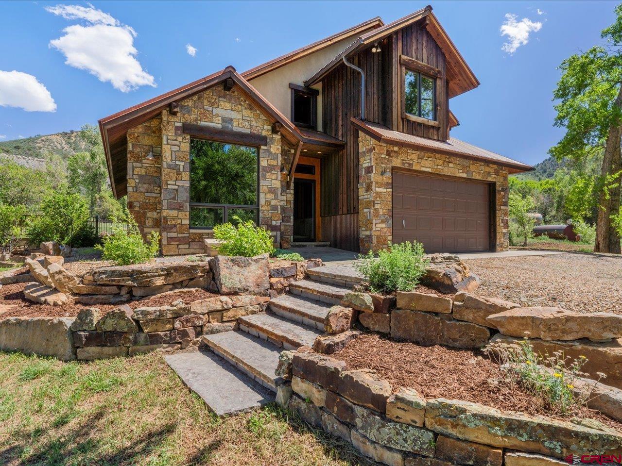 Welcome to your own private piece of paradise. this property is tucked away among towering Cottonwood trees overlooking 36.6 acres of lush green pastures.  Approaching the property with the Cimarron Mountain range in the background, your eye is drawn to the amazing stonework, architecture and rustic design of this home. The idyllic setting is supported by the Dallas ditch for irrigation water. Historically the property has been used as a horse property with several turnout sheds and a four-stall panel shelter.  Out buildings include an equipment barn and storage buildings. The property has pipe fencing as well as smooth wire for various turn-out areas.  Completely remodeled in 2021, they thought of everything. Beautiful custom Alder cabinets and trim, laminate antique oak flooring and plush carpeting in the bedrooms. Custom metal railings lead you to the primary bedroom that is en-suite including a walk-in shower, double vanity and soaker tub. The other 2 bedrooms share a bath with a granite counter and walk-in shower. The kitchen is totally open with quartz counter tops, LG appliances and tons of storage.  Two dining areas offer great options, one in the kitchen creating a farm style setting and another near the living room for a more formal setting.  A built-in seating area offers your guests a place to visit with the cook rather than a bar top.  The 1500 sq. ft. stone patio is Pennsylvania Blue stone and is lined with Colorado Sandstone bedding areas.  An entertainer’s dream. The rustic enclosed airlock entrance leads you to a 4-foot custom alder door opening into the living area with vaulted ceilings that are lined with tongue and groove Aspen and Alder trim. Large picture windows allow natural light to flow in while you view the wildlife passing by. The location of this amazing property can’t be beat.  Sitting just 1.5 miles west of the town of Ridgway, and all that it offers, world famous Telluride Ski area is 40 minutes west, historic City of Ouray, the “Little Switzerland of America” the Divide Golf and Ranch Club are all great places to play just minutes away. Our supply town of Montrose north 30 minutes has a regional airport, excellent health care facilities and shopping.  Bring the critters or just enjoy the natural beauty this versatile Southwestern Colorado property has to offer! Make your appointment today!