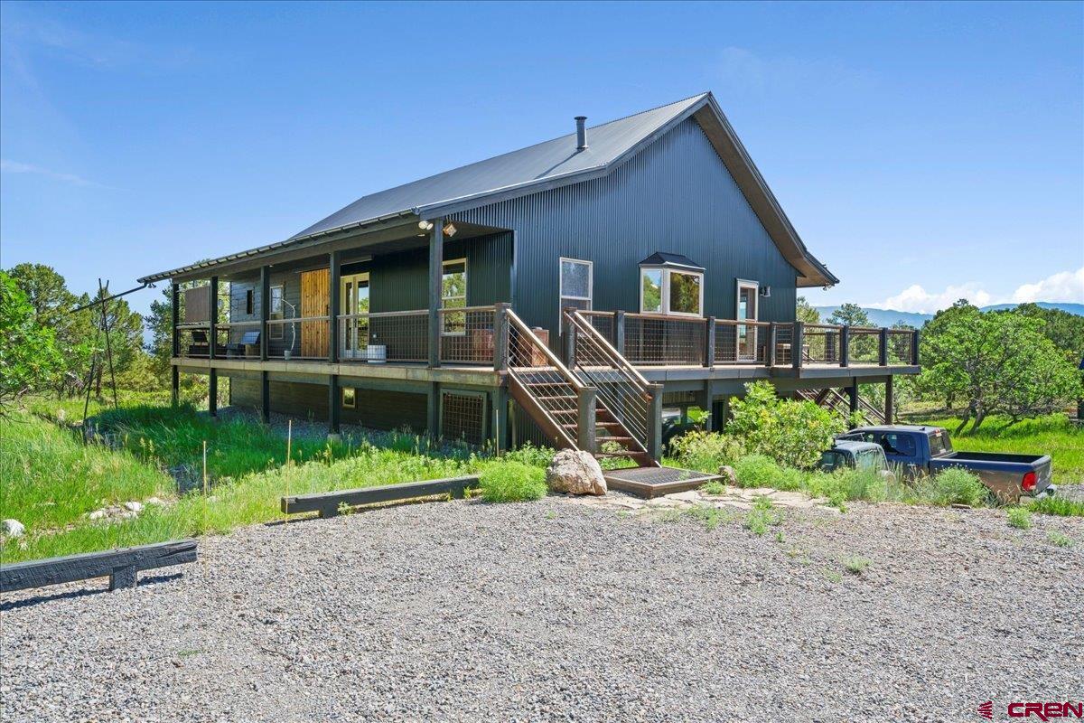 Experience the best of Colorado mountain living in this beautifully updated single-family residence, located above the charming town of Ridgway in desirable Loghill Village. Nestled on 5 private acres surrounded by towering Ponderosa, Piñon, and Juniper trees, this home offers the perfect combination of seclusion and breathtaking views. Enjoy panoramic vistas of the Cimarron Ridge in the San Juan Mountains on the expansive wrap-around deck. Inside, the home features modern mountain rustic finishes, creating a warm and inviting atmosphere. Thoughtful built-ins throughout the home provide abundant storage and help keep your spaces organized. The open-concept living area is ideal for entertaining. With three bedrooms and three baths, there’s plenty of room for family and guests, as well as a separate office, and a private studio offering peaceful retreats. A heated two-car attached garage adds convenience year-round, whether you’re heading out for adventure or returning home to watch the alpenglow light up the peaks.