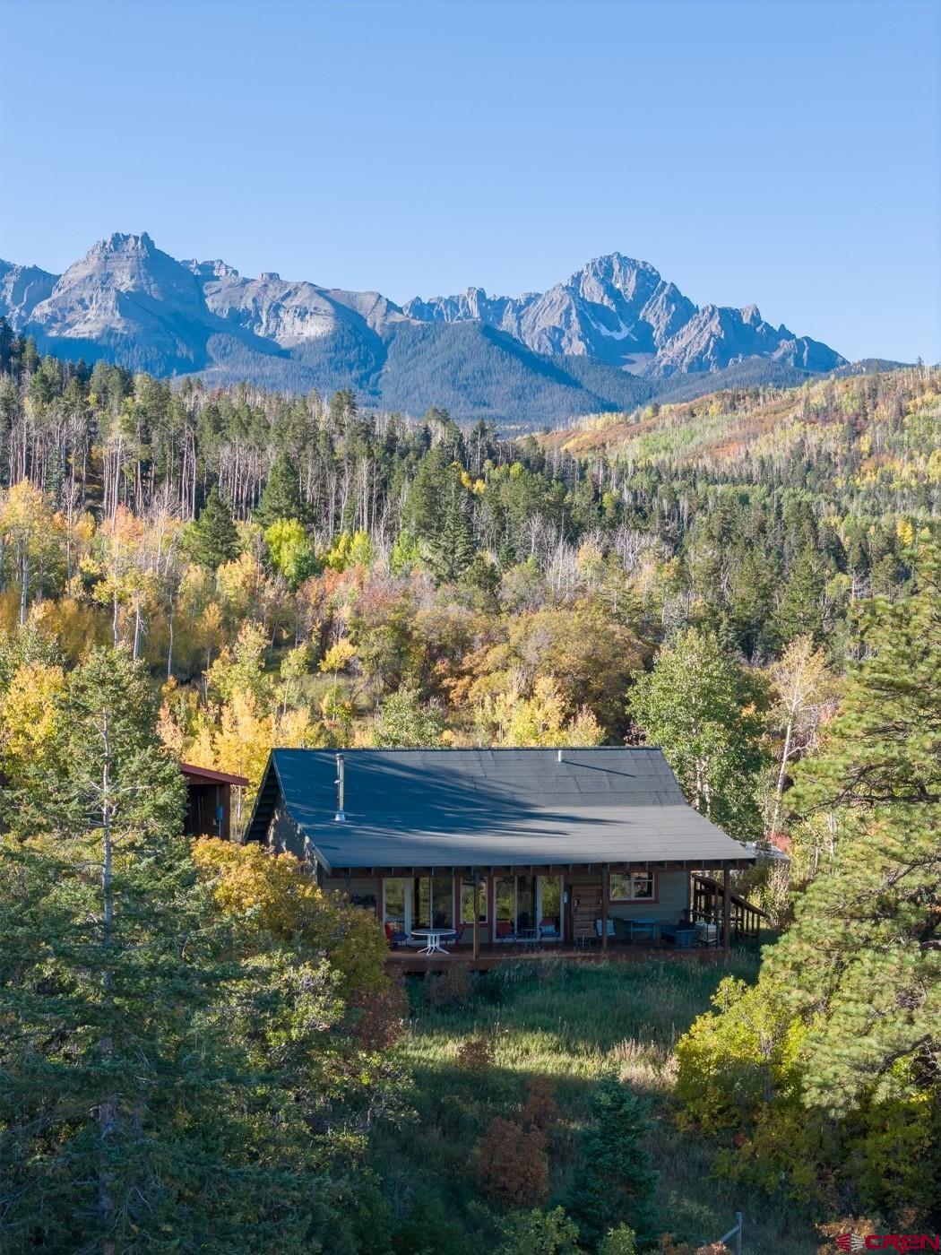 OURAY AREA MOUNTAIN HOME WITH HORSE FACILITIES AND DIRECT NATIONAL FOREST ACCESS!  Park Estates has become one of the area's most prestigious areas because of the high quality homes, excellent views, access into public lands, and year round access.  It's located on the western ridges overlooking the Ridgway and Ouray Valley.  And its private gated access makes sure that the community's roads remain in great shape.  For those of you looking for a horse friendly retreat, you simply couldn't do any better and the trails and public lands of Park Estates will become your playground.  The main home is beautiful and carefully crafted to serve as a perfect year round permanent residence or seasonal escape.  It was built for the owners by favorite Ouray County Builder Allison construction to be easy to maintain and comfortable.  There are 1200 square feet, with a nicely sized great room that has wonderful mountain and valley views.  You'll love the white oak floors, vaulted pine tongue and groove ceilings, quality wood stove set in its northeast corner.  Sliders allow you to walk out to another 480 square feet of covered outside living space that overlooks the town of Ridgway and allows you to peer down toward Coal Creek with is located on the lower portions of the property.  The kitchen and dining room areas are on the west side of the home, with a well appointed kitchen that boasts quality appliances.  Of special significance is two side by side refrigerator freezers-a nice idea to be sure you're properly prepared for visitors.  Both bedrooms are quite nice-the primary has a large bath with soaking tub and shower that looks south to the mountains.  The second bedroom, which is perfect for an office, workout room or studio too, is situated in the southeast corner, and the second bath is located nearby, off of the great room, for the convenience of not just your family but also your guests.  Dependable utilities are important in the mountains, and the state of the art water system is dialed in to provide excellent water through the Park Estates water system.  The water, along with the road maintenance are included in the low annual dues.  The horse barn created on the property is a horse person's dream.  It was designed by the owner and constructed by Allison construction.  it incorportates the best of designs for this area,  including a long wall along its south side to protect from storms, a high vaulted roof with three stalls that have concrete floor set up on wood slats that lead out to a large open covered area. The property has been carefully fenced for the maintenance of horses and beauty. The rides  you'll take out to your personal trails as well as from this property into the National Forest will be a unique delight for you, your family and friends.  Thousand of acres of public land await your adventures.  Near the barn is a storage building, ready for the storage of your toys, and set up to be a carport for cars or your ATV.  it's situated perfectly beteen the home and barn.  What's your Colorado dream?  Is it land where you can enjoy it now with the plan to expand someday?  Maybe it's your year round home privately locacate away from the towns and surrounded by deer and elk and other wildlife?  Perhaps its a weekend  or summer home, away from heat and humidity?  No matter what your vision, this quality home on 39 acres in Park Estates has all you need!