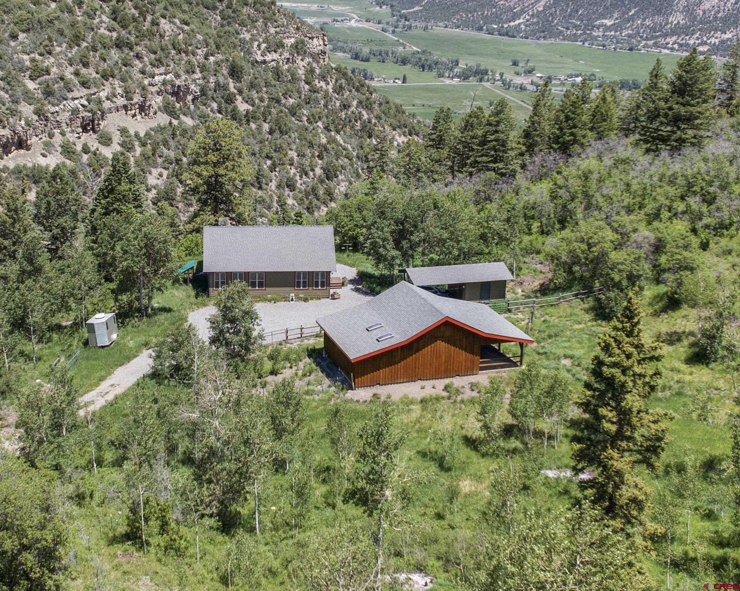 OURAY AREA MOUNTAIN HOME WITH HORSE FACILITIES AND DIRECT NATIONAL FOREST ACCESS!  Park Estates has become one of the area's most prestigious areas because of the high quality homes, excellent views, access into public lands, and year round access.  It's located on the western ridges overlooking the Ridgway and Ouray Valley.  And its private gated access makes sure that the community's roads remain in great shape.  For those of you looking for a horse friendly retreat, you simply couldn't do any better and the trails and public lands of Park Estates will become your playground.  The main home is beautiful and carefully crafted to serve as a perfect year round permanent residence or seasonal escape.  It was built for the owners by favorite Ouray County Builder Allison construction to be easy to maintain and comfortable.  There are 1200 square feet, with a nicely sized great room that has wonderful mountain and valley views.  You'll love the white oak floors, vaulted pine tongue and groove ceilings, quality wood stove set in its northeast corner.  Sliders allow you to walk out to another 480 square feet of covered outside living space that overlooks the town of Ridgway and allows you to peer down toward Coal Creek with is located on the lower portions of the property.  The kitchen and dining room areas are on the west side of the home, with a well appointed kitchen that boasts quality appliances.  Of special significance is two side by side refrigerator freezers-a nice idea to be sure you're properly prepared for visitors.  Both bedrooms are quite nice-the primary has a large bath with soaking tub and shower that looks south to the mountains.  The second bedroom, which is perfect for an office, workout room or studio too, is situated in the southeast corner, and the second bath is located nearby, off of the great room, for the convenience of not just your family but also your guests.  Dependable utilities are important in the mountains, and the state of the art water system is dialed in to provide excellent water through the Park Estates water system.  The water, along with the road maintenance are included in the low annual dues.  The horse barn created on the property is a horse person's dream.  It was designed by the owner and constructed by Allison construction.  it incorportates the best of designs for this area,  including a long wall along its south side to protect from storms, a high vaulted roof with three stalls that have concrete floor set up on wood slats that lead out to a large open covered area. The property has been carefully fenced for the maintenance of horses and beauty. The rides  you'll take out to your personal trails as well as from this property into the National Forest will be a unique delight for you, your family and friends.  Thousand of acres of public land await your adventures.  Near the barn is a storage building, ready for the storage of your toys, and set up to be a carport for cars or your ATV.  it's situated perfectly beteen the home and barn.  What's your Colorado dream?  Is it land where you can enjoy it now with the plan to expand someday?  Maybe it's your year round home privately locacate away from the towns and surrounded by deer and elk and other wildlife?  Perhaps its a weekend  or summer home, away from heat and humidity?  No matter what your vision, this quality home on 39 acres in Park Estates has all you need!