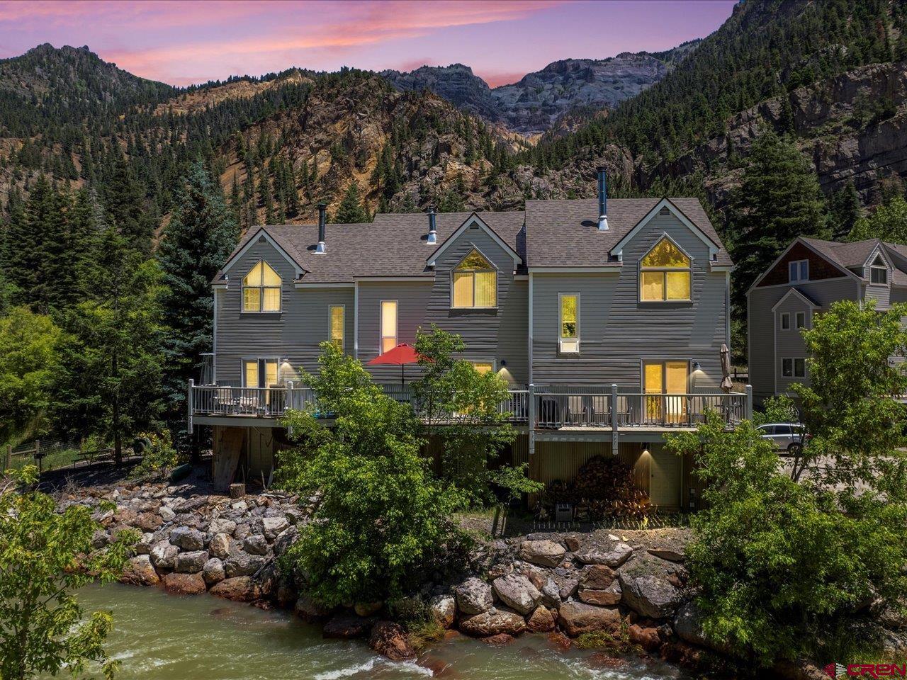 This is a special offering.  This completely remodeled in 2022, town home sits right on the Uncompahgre River and has been a very successful short term rental.  The finishings and furnishings are top of the line.  The location is perfect, within walking distance to all the shops, restaurants and attractions in town.  Best of all, the hot springs pool is across the street. The two bedroom, bath and a half unit, is three stories and has a one car attached garage.  The great room, on the second floor, has a very nice deck with a red umbrella and patio table and chairs, pellet stove to keep it toasty in the winter, upgraded lighting and big windows for lots of natural light.  There is a half bath along with the living room, dining room and kitchen. The top floor has a full bath and the two bedrooms, each with mountain views and beautiful furnishings.  The lowest level has your entry with a bench to take off your shoes, a clothes washer and dryer and a one car garage.  There is a covered covered patio off the 1st floor and lots of attic storage. The remodel was extensive.  It includes all new flooring, luxury vinyl, tile and carpet.  New raised panel doors, and new base and case trim.  Hickory cabinets in the kitchen with quartz countertops, new appliances, light fixtures, plumbing fixtures, European style shower with custom shower pan, window treatments, and paint throughout.  With special furnishings like reclaimed barnwood custom headboards and closet shelving along with the beds, sofas, chairs, dining room and patio furniture. The rental calendar is pretty full so we have included a virtual tour so you can see it even when it is occupied.  The short term license is not transferable but the city of Ouray has not met the cap for licenses.  Since this is a short term rental you know it will pass the inspection to gain your own license.   Check it out.  It's an incredible income producing river front property!!  Seller is willing to transfer all booked stays to the new owner.