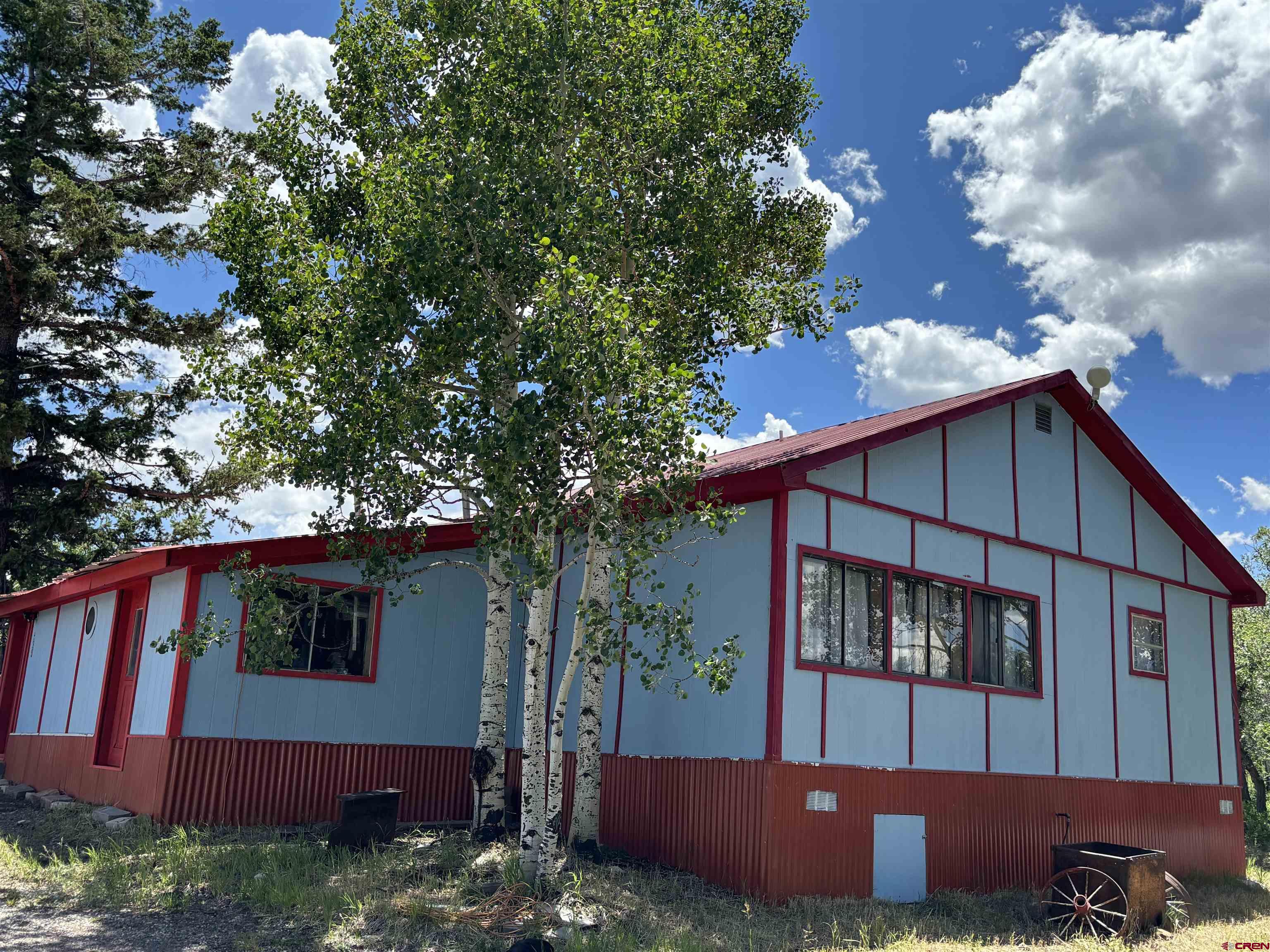 Escape to serenity in the mountains with this charming 4-bedroom, 3-bathroom manufactured home nestled on 1.21 acres amid majestic Aspen trees in the coveted Elk Meadows Estates community of Ridgway, CO. Spanning 2,025 square feet, this 1979-built residence offers an ideal canvas for those eager to customize and infuse with modern touches.  Step inside to discover a welcoming blend of laminate, carpet, and tile floors throughout. The open layout seamlessly integrates living, dining, and kitchen areas, while a dedicated room provides the perfect workshop, hobby space, or home office—supported by fiber-optic internet for seamless connectivity.  Outside, an oversized storage shed provides ample space for gear, tools, or seasonal supplies. Imagine sipping coffee or hosting gatherings on the spacious grounds shaded by Aspen groves, with peaceful views of the surrounding peaks.  Located under two miles from pristine National Forest access and just minutes from downtown Ridgway, this home places outdoor adventure right at your doorstep. Explore hiking trails or the San Juan Hut System, enjoy winter sports like skiing and snowmobiling, or simply immerse yourself in wildlife—elk, deer, turkey, and more are frequent visitors.  Elk Meadows Estates is a serene, incorporated mountain subdivision known for its natural spring water and tight-knit, nature-loving community. Plus, with strong demand for rentals in the area, this property doubles as an attractive long–term investment.  Opportunities like this, at such an accessible price, don’t come around often. Embrace the mountain lifestyle you’ve been dreaming of—schedule your private showing today!