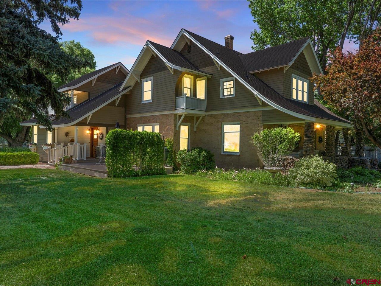 Step into a living fairytale with this breathtaking 4-bedroom, 3-bath farmhouse nestled in the heart of Montrose, Colorado. Set on 2.64 irrigated acres of lush, professionally landscaped gardens, this 3,789 sq ft home is a rare blend of timeless charm and modern luxury. From the moment you arrive, the property's enchanting ambiance draws you in. Majestic evergreens, flowering apple trees, and mature deciduous trees surround the grounds, creating a private sanctuary that feels worlds away. A pond with a tranquil seating area, berm, and cascading waterfall anchors the outdoor oasis, while historic outbuildings including a classic red barn, a concrete milk house, a charming “She-shed,” and a cozy guest cabin enhance the storybook setting. At the heart of the estate is the beautifully preserved late-1800s Spring Creek farmhouse, brimming with vintage character and thoughtful updates. Leaded glass windows welcome you into a warm and spacious living area, where original hardwood trim, built-in nooks, and exposed brick details evoke a deep sense of nostalgia. The chef’s kitchen is both functional and elegant, featuring an apron-front farmhouse sink, high-end appliances, stylish fixtures, and a large butler’s pantry, perfect for entertaining. Upstairs, the dual-entry staircase leads to a cozy landing with a window seat, three uniquely charming bedrooms, and a master suite that’s nothing short of dreamy. Enjoy garden views and sunshine through oversized windows, a sitting area for quiet moments, and a luxurious master bath with a steam shower, clawfoot tub, pedestal sink, and a walk-in closet. French doors lead to a private balcony with sweeping views, ideal for morning coffee or evening relaxation. Rounding out this stunning property is a welcoming river rock front porch, just one more detail that completes the farmhouse charm. Whether you're looking for a peaceful homestead, a gardener’s paradise, or a home that simply inspires joy, this one-of-a-kind Montrose retreat is where dreams truly come to life.