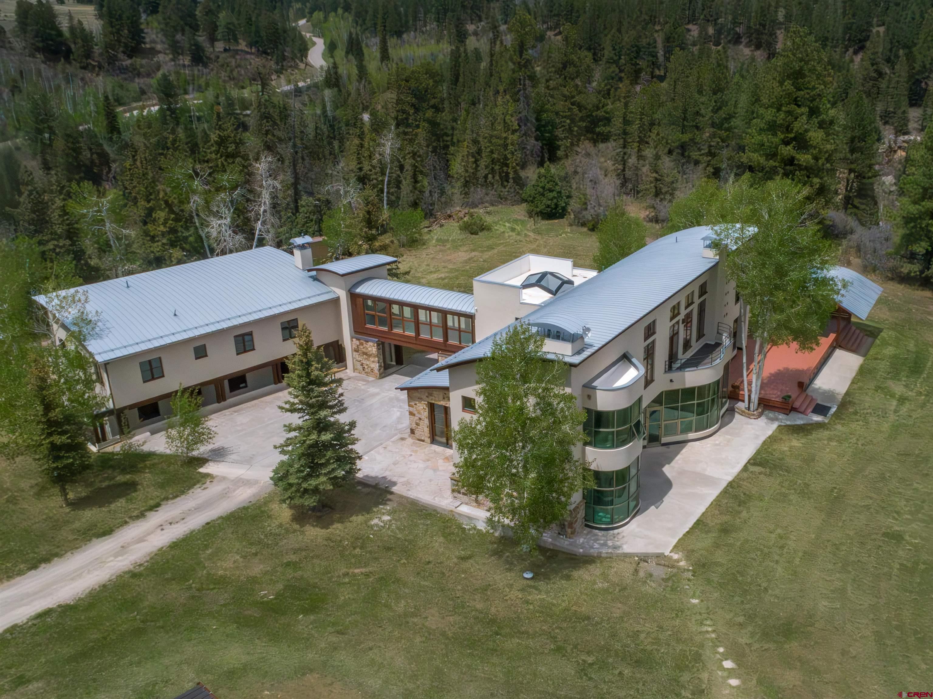 This Lipkin-Warner residence offers an exceptional opportunity to own a mountain retreat. Situated in the heart of the San Juan Mountains, it's also conveniently located just 35 minutes from Telluride. This exquisite home serves as the perfect base camp for a wide range of outdoor adventures, including hunting, fishing, mountain biking, golfing, and skiing.  Enjoy convenient winter access thanks to the mostly paved roads leading to the property. Once home, you can relax to the sounds of Red Tail Hawks while taking in the stunning panoramic views of the San Juan mountain range. Nestled on 38 private acres in a serene meadow, the property offers a remarkable sense of seclusion.  The main house features five generously sized bedrooms, complemented by an attached caretaker's quarters. This additional space is ideal for accommodating extended guests or could serve as a private studio or office. The recently remodeled modern custom home features an expansive great room, a wood-burning fireplace and a chef's kitchen.