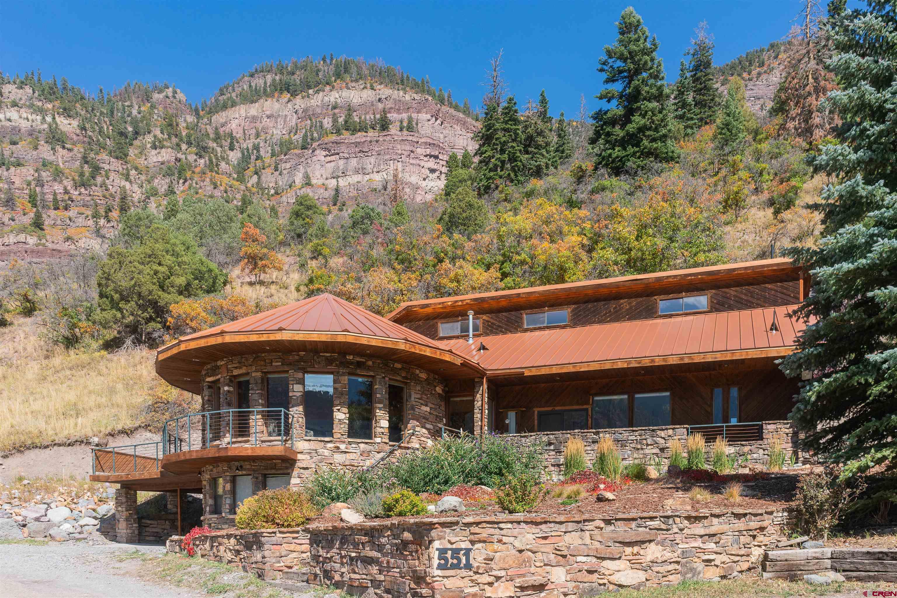 LOCATION IS PRIME FOR THIS beautiful home if you are looking for views.  This Iconic home sits at the top of the world looking toward mountains in all directions and sits with an overview of the City of Ouray from inside and outside of the home.  And yet, you are five minutes from downtown Ouray.  Easily reconizable from downtown Ouray with it's unique architechural style, just waiting for you to move in.  Surrounded by windows, the Living Room has beautiful Hickory floors carried out into the Dining Room and Kitchen.  Kitchen has built in breakfast nook, all stainless appliances including double ovens, dishwasher, 5 burner cooktop, microwave and a large walk-in pantry. There are 3 levels in this home.  The main floor where kitchen and living room are located also has a large office space with built in cabinets, just off of the laundry room with a 3/4 bath.  The Washer and Dryer are included.  Just around the corner you will find a 1/2 bath along with a large family room/den with a gas fireplace with granite and access to a small covered patio. One floor down  is the large and very private Master bedroom also surrounded by windows with views, and a large full bath with soaking tub and separate steam shower, double vanity and huge walk-in closet.  You can also access from this level  the garage/workshop.    One level up from the main level you will find an additional 4 bedrooms each with their own bathroom. There are patios and decks all around the home, including a hottub. There are two furnaces and the heat is gas forced air.   While some renovations are currently being finished you will see the  Newer roof on the home, new Marvin windows, new interior paint in some rooms, fixtures, etc.  This house is one to put on your list to see, there are very few homes like it in Ouray.   PLEASE NOTE:  Previously the home was being sold with two vacant lots.  Those lots are being subdivided from the home and sold seperately. Therefore, the price change is for the House only. Also some upgrades to the house are currently being made including interior paint, new carpet, new bathroom upstairs with glass shower door being installed and upgrade to patio and decking.  The lot with the house will be approximately 1 acre total  providing plenty of space for a new garage and large deck to be built  by the new owner.  Final Planning approval by the City of Ouray will be required prior to closing on the home.