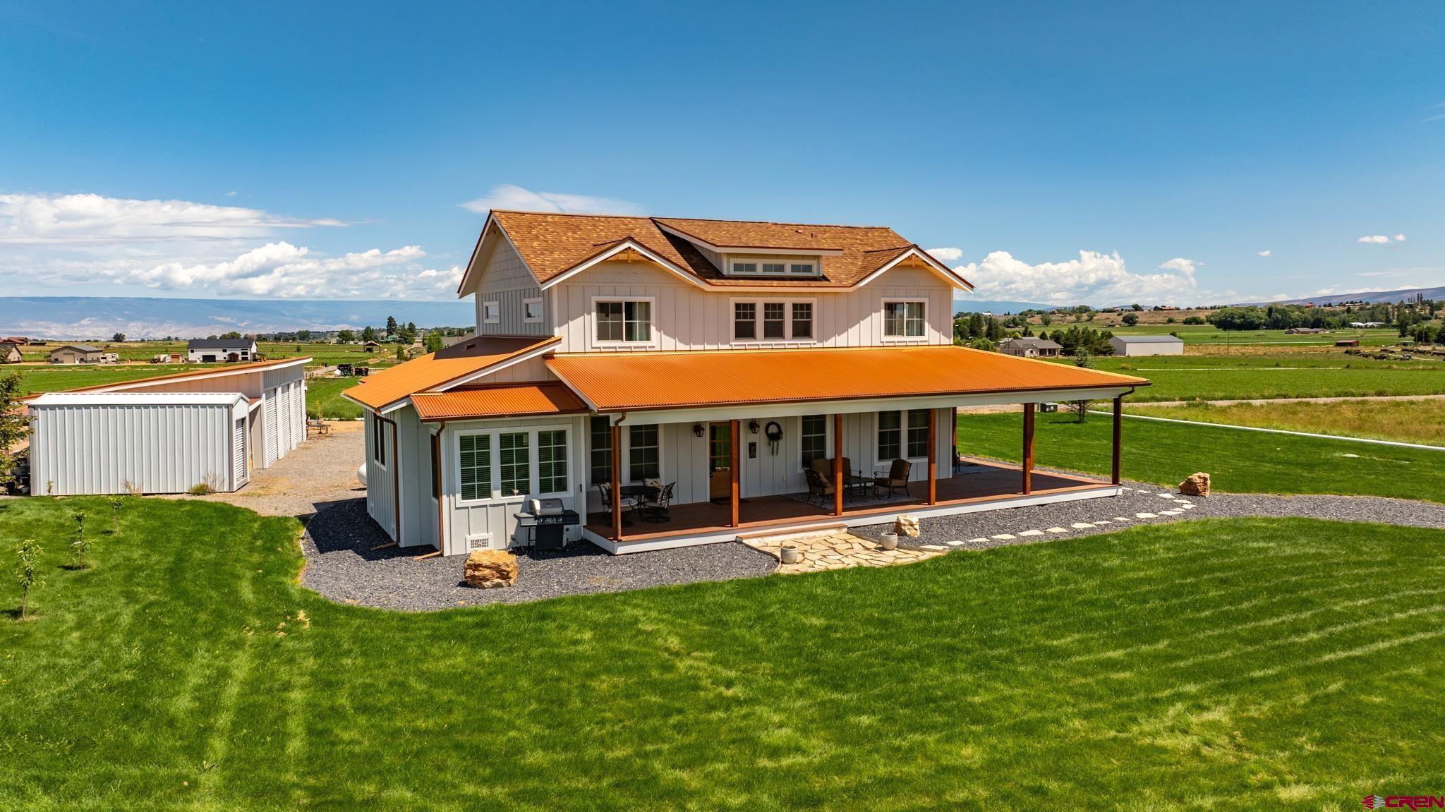 Experience the perfect blend of modern comfort and country living in this beautifully crafted modern farmhouse, built in 2019 and nestled on over 7 irrigated acres in scenic Shavano Valley. A wraparound covered porch welcomes you home and provides the ideal perch to enjoy sweeping views of your acreage and the mountains beyond. Inside, the inviting country kitchen features quartz countertops, soft-close cabinetry, a farmhouse sink, and plenty of space for gathering and entertaining. The main-level master suite offers a serene retreat with a beautifully tiled shower and dual vanities. Upstairs, you’ll find three additional bedrooms, a full bath, and a versatile 200-square-foot flex room perfect for an office, playroom, or hobby space. A spacious three-car attached garage pairs with a detached three-bay workshop, offering abundant room for vehicles, equipment, or projects. The property is thoughtfully landscaped with an underground sprinkler system for the yard and gated irrigation pipe for the field. With plenty of open space, the land can easily be set up for horses by adding fencing and a few outbuildings. Adventure is right at your doorstep with nearby public lands ideal for horseback riding, off-roading, biking, and hiking. Enjoy in-floor radiant heat, central air conditioning, and a tankless on-demand hot water heater for year-round comfort. Conveniently located just minutes from Montrose and the regional airport with easy access to some of Colorado’s best outdoor destinations, including the Ouray Hot Springs, world-class skiing in Telluride, Ridgway Reservoir, gold-medal fishing on the Gunnison River, and countless hiking and jeep trails. This is Colorado living at its finest—private, picturesque, and close to everything.