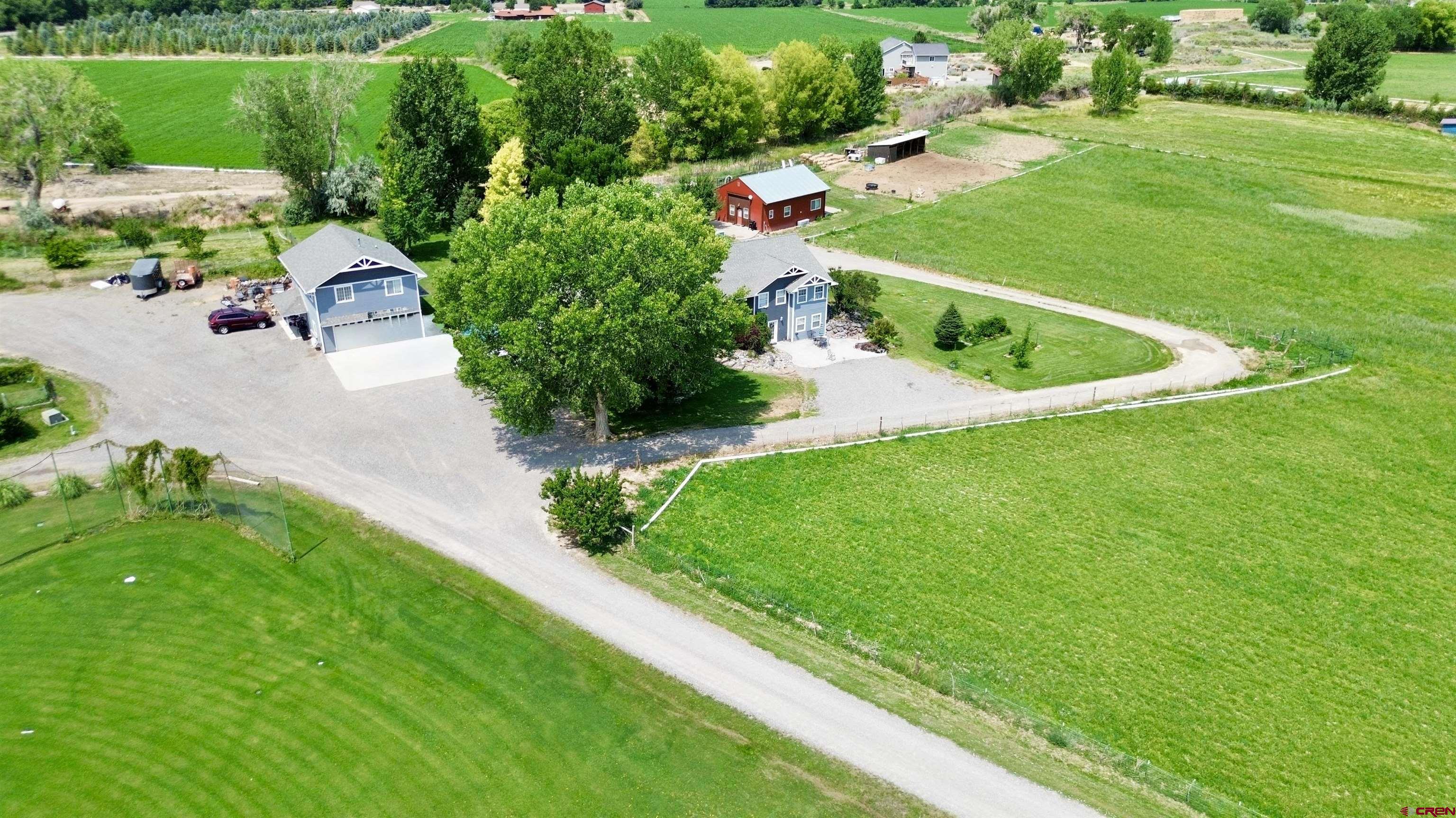 Ideal for multi-generational living or added income with a walk-out basement apartment, and two additional dwelling units (ADUs) situated a 7.6 acres. The main home has been meticulously maintained and features a stunning newly remodeled kitchen with quartz countertops, a tiled backsplash, an expanded window overlooking the backyard, a built-in coffee bar, and a spacious laundry room/pantry. Enjoy the main living area with hardwood flooring and a fantastic family/game room, complete with a fireplace and roll-up door that opens to a large patio, perfect for seamless indoor/outdoor entertaining.  In addition, on the main level you'll find three bedrooms, including a generous master suite with a walk-in closet, an ensuite with a separate shower and bathtub, and a full main bathroom. The lower level with its own entry can be locked off for a separate ADU and boasts a spacious great room/office, a fully remodeled  kitchen with all appliances and soft close cabinets as well as a new stackable washer/dryer, two bedrooms (one non-conforming) and access to a private patio with a firepit. The attached two-car garage compliments a detached two-car garage with a second ADU of 884 sq. ft. of living space above. This separate unit includes a full kitchen, living area, two bedrooms, and full bath. A third ADU is a separate 988 sq. ft. one-bedroom bunkhouse, adding even more possibilities, featuring a living area, 3/4 bath, and full kitchen. Both spaces include stackable washers and dryers.  The property is a haven for outdoor enthusiasts and gardeners alike, with pasture space for animals with a new lean-to barn for their protection, a large garden area, two sheds, a chicken coop (chickens included), and irrigation water for the lawn and pasture. An abundance of fruit trees—apple, pear, apricot, peach, and plum—plus raspberries, blackberries, blueberries, cherries, rhubarb, grapes, and herbs make this property a gardener's dream. Located close to the best of Colorado’s outdoor lifestyle, you’re just a short drive from the Ouray Hot Springs, world-class skiing in Telluride, Ridgway Reservoir for paddleboarding, gold-medal fishing in the Gunnison River, and endless hiking, biking, and jeep trails. The Montrose Regional Airport is only 10 minutes away for easy travel access. Discover the endless possibilities of this one-of-a-kind property and make it your next home today! (Listing agent is related to Seller.)