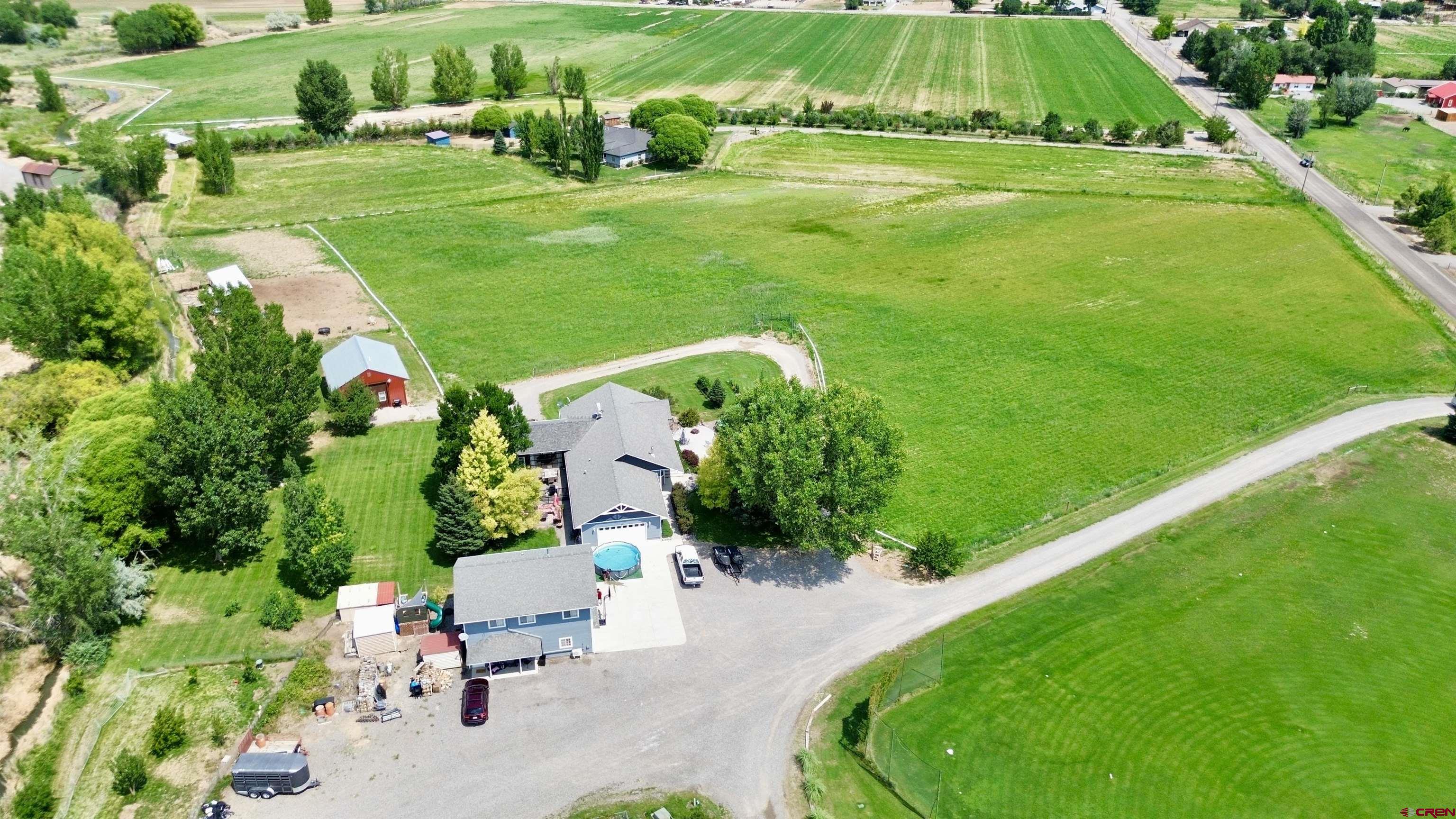 Ideal for multi-generational living or added income with a walk-out basement apartment, and two additional dwelling units (ADUs) situated a 7.6 acres. The main home has been meticulously maintained and features a stunning newly remodeled kitchen with quartz countertops, a tiled backsplash, an expanded window overlooking the backyard, a built-in coffee bar, and a spacious laundry room/pantry. Enjoy the main living area with hardwood flooring and a fantastic family/game room, complete with a fireplace and roll-up door that opens to a large patio, perfect for seamless indoor/outdoor entertaining.  In addition, on the main level you'll find three bedrooms, including a generous master suite with a walk-in closet, an ensuite with a separate shower and bathtub, and a full main bathroom. The lower level with its own entry can be locked off for a separate ADU and boasts a spacious great room/office, a fully remodeled  kitchen with all appliances and soft close cabinets as well as a new stackable washer/dryer, two bedrooms (one non-conforming) and access to a private patio with a firepit. The attached two-car garage compliments a detached two-car garage with a second ADU of 884 sq. ft. of living space above. This separate unit includes a full kitchen, living area, two bedrooms, and full bath. A third ADU is a separate 988 sq. ft. one-bedroom bunkhouse, adding even more possibilities, featuring a living area, 3/4 bath, and full kitchen. Both spaces include stackable washers and dryers.  The property is a haven for outdoor enthusiasts and gardeners alike, with pasture space for animals with a new lean-to barn for their protection, a large garden area, two sheds, a chicken coop (chickens included), and irrigation water for the lawn and pasture. An abundance of fruit trees—apple, pear, apricot, peach, and plum—plus raspberries, blackberries, blueberries, cherries, rhubarb, grapes, and herbs make this property a gardener's dream. Located close to the best of Colorado’s outdoor lifestyle, you’re just a short drive from the Ouray Hot Springs, world-class skiing in Telluride, Ridgway Reservoir for paddleboarding, gold-medal fishing in the Gunnison River, and endless hiking, biking, and jeep trails. The Montrose Regional Airport is only 10 minutes away for easy travel access. Discover the endless possibilities of this one-of-a-kind property and make it your next home today! (Listing agent is related to Seller.)
