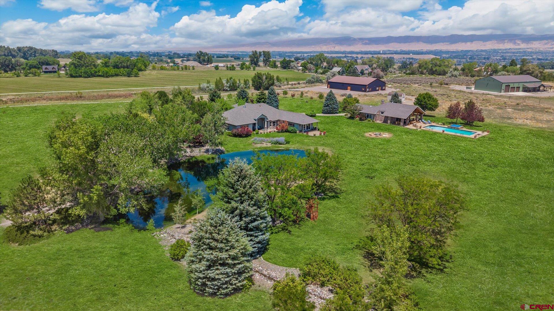 Family Compound on 30 Acres: Two Homes, Main home 3238 sqft 4bed3bath,Guest home 1526 sqft 3bed3bath + 6,000 Sq Ft Barndominium caretaker apt with 1.5 bath, office and storage. Private Gated | Pool + Ponds + Views. A truly extraordinary compound nestled on 30acres, (9 irrigated), San Juan Mountain views. Features two custom single-family homes, an impressive 6,000 sq ft barndominium/shop, two ponds with waterfalls, and a resort-style pool—all designed for comfortable, luxurious, and versatile living.As you enter through the gated drive, a winding, tree-lined driveway leads to beautifully landscaped grounds supported by 3.2 shares of irrigation water and well, ensuring abundant water for mature landscaping, fruit trees, pollinator gardens, and more. The lined ponds and tranquil waterfall create a peaceful ambiance the moment you arrive. Main Residence Highlights: • Open-concept floorplan with high ceilings, art niches, and natural light throughout • Flowing layout from the great room to a second family/game room with a wet bar—ideal for entertaining • Primary suite features private patio access, travertine and slate flooring, jetted soaking tub, and seamless glass walk-in shower • Gas fireplace, air conditioning, and ceiling fans throughout • Four-car garage with stamped concrete driveway Second Home (ADU/Guest House): • 3 bedrooms | 2.5 bathrooms  • Thoughtfully designed with custom finishes • Versatile use as guest quarters, multigenerational living, or a pool house,  6,000 Sq Ft Barndominium/Shop (Built 2018): • Five oversized overhead doors to accommodate large vehicles, RVs, and equipment • Includes a dedicated office and caretaker’s apartment  • Fully heated and cooled for year-round use • Ideal for hobbyists, car collectors, business operations, or eventsOutdoor Oasis: • In-ground pool with hot tub, pool bath, outdoor shower, and solar cover • Covered patio with views of the ponds and water garden • Fire pit for cozy evenings and incredible sunsets  • Raised garden beds, fruit trees, equipment shed, and pollinator gardens  • Automated sprinkler system and mature trees throughout the landscape Additional Features:  • Private fenced entry and serene surroundings  • Potential to subdivide and sell off two parcels, while retaining the two homes and the barndominium on 10 acres  • Ready for multigenerational living, business use, or private retreat potential This property is a rare opportunity to own a true Colorado retreat—complete with luxury, functionality, HUGE VIEWS.