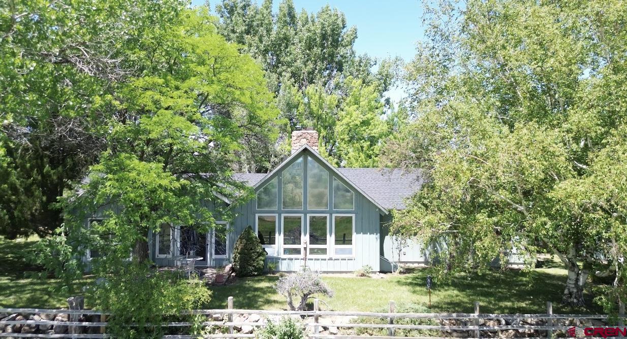 Come discover this private sanctuary tucked away down a quiet aspen-lined drive. Set on 13 acres, this rare retreat on Spring Creek Mesa lets you experience the Colorado lifestyle so many dream about. You’ll enjoy wide-open views, a peaceful pond stocked with fish, and the privacy that’s getting harder to find. Mature trees and irrigated pastures (with 10 shares of UVWUA water) make this a perfect spot for horses, hobby farming, or simply stretching out and taking in the scenery. The charming cottage-style home has vaulted ceilings with rustic beams and oversized windows that fill the space with light and frame beautiful views. A loft adds extra space for an office, studio, or quiet reading nook, while the split floor plan with 3 bedrooms and 2 baths offers both comfort and privacy. The primary suite features high ceilings, big windows, and an ensuite bath with dual sinks and a tiled shower. The house has good bones—hardwood floors, character details—and is ready for a buyer to bring their vision and make it their own creating a truly legacy property. Outside, there’s a barn for equipment or animals, a loafing shed, and a dedicated spot that could be set up for chickens. The detached garage has two main bays plus a lower third bay for storage or a workshop. Peaceful, private, and truly one of a kind, this is a chance to own your own slice of Colorado just minutes from town but a world away from it all. No HOA, no covenants—just open space, fresh air, and endless possibilities.