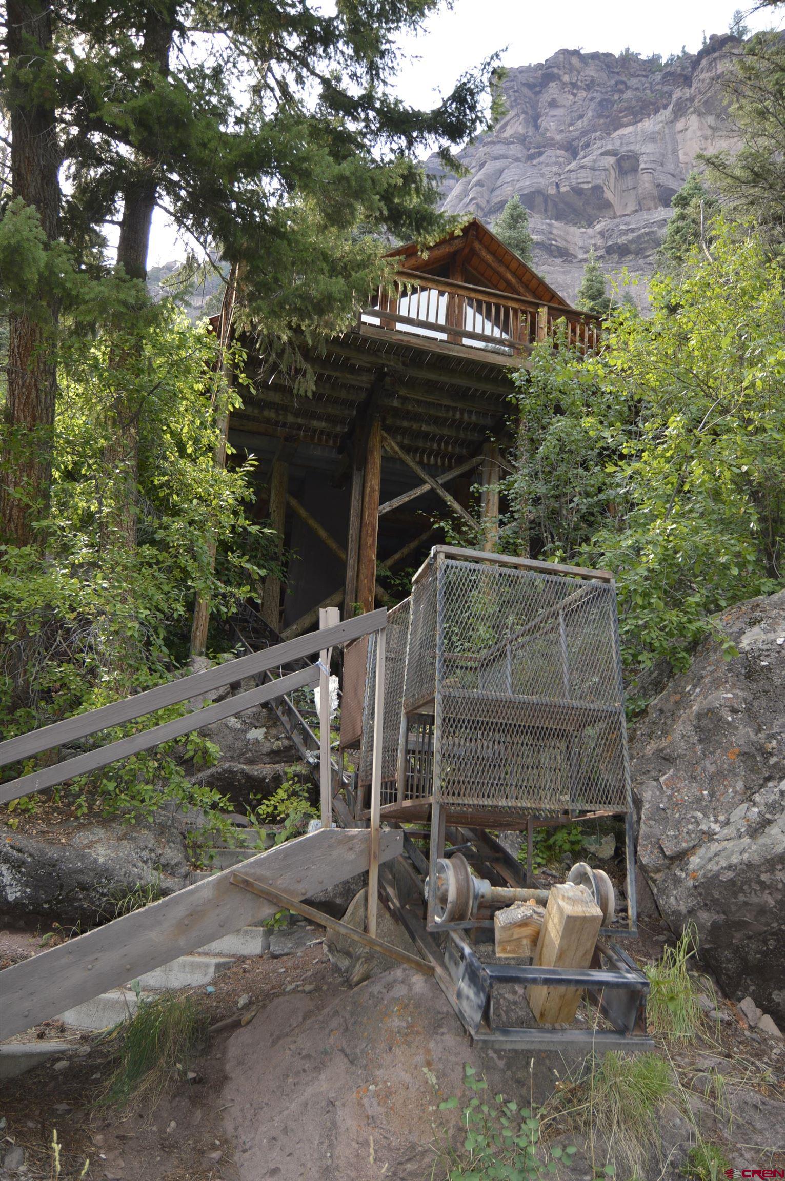 600 N Pinecrest Drive | Ouray, Colorado Million-Dollar Views. Legendary History. Rare Opportunity.  Perched on 1.75 acres at the very end of N Pinecrest Drive, this one-of-a-kind property offers breathtaking, unobstructed views of Ouray’s iconic Amphitheater. This is truly the last house on the road—private, peaceful, and with no future expansion past this home, offering the kind of seclusion rarely found this close to town. This property ends where the Uncompahgre National Forest begins!   Known locally as "The Treehouse" in the 1980s and once home to legendary trucker country musician C.W. McCall, this four-bedroom, two-bath home blends history, character, and potential. While not fully finished—remodel efforts following a burst pipe are still in progress—it’s on city utilities and ready for your vision to bring it to life.  The property includes a detached two-car garage and a unique private tram (currently under repair) that transports you from the driveway to the home's elevated entry—a feature as fun as it is functional. Set on a generously sized parcel with ample space to explore, this land even includes the site of The Fisherman Lode.   Enjoy the feel of mountain wilderness with all the convenience of town utilities and proximity just minutes from downtown Ouray. Whether you’re drawn by the views, the history, or the chance to make something uniquely yours—this is a rare opportunity in a truly unbeatable location.