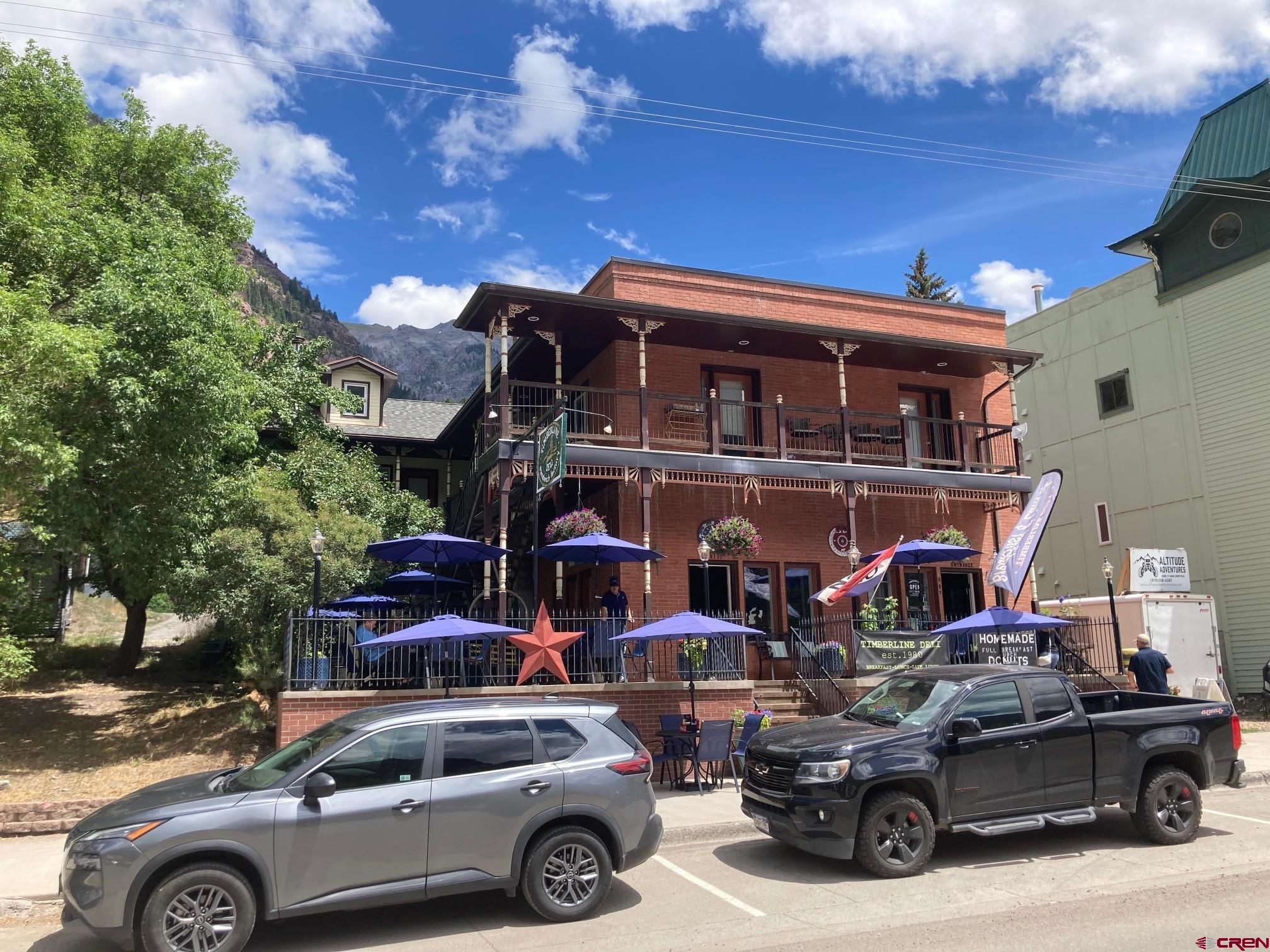 One of the best investment properties available in Ouray County, Colorado! Whether you're looking for a strategic landing spot for your 1031 exchange funds or a secure, low-maintenance real estate investment, this turn-key Ouray condo delivers. Ideally located in the heart of downtown Ouray—just behind the ever-popular Timberline Deli—you’re tucked away just enough to enjoy privacy and quiet, yet steps from Main Street, hiking trails, and all the charm the "Switzerland of America" has to offer.  Wide steps from the Timberline patio lead you up to a bright and welcoming covered front porch with beautiful western views of the iconic Rock of Ages. Inside, you’ll find a sun-filled living and dining area featuring hardwood floors, a wood-burning stove, and soaring ceilings that create an open, airy feel. The smart layout offers generous space and natural light throughout.  Fully remodeled just a few years ago, this two-bedroom, two-bath condo includes a stylish kitchen and modern finishes, making it perfect for full-time living, a weekend getaway, or a live-work setup. It's currently leased to ideal long-term tenants through May 2026, giving you immediate and reliable income. For those seeking short-term rental potential, it may be eligible for STR use pending City of Ouray approval and license availability.  Additional highlights include dedicated off-street parking behind the building, plus a private one-car garage (southernmost bay off the alley) for added convenience. The well-managed, small HOA handles exterior maintenance, making this a hassle-free ownership opportunity whether you're local or out of town.  Relax on your peaceful back deck and take in breathtaking views of the Amphitheater, especially vibrant during fall’s color change. This rare Ouray condo is move-in ready and ideally suited for year-round living, seasonal retreats, or smart investment income. Don’t miss your chance—schedule your private showing today!