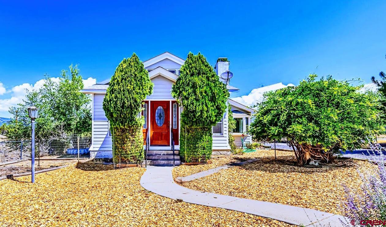 CHARMING CRAFTSMAN STYLE HOME ON HALF ACRE WITH GRAND MESA VIEWS IN CEDAREDGE! Step into Timeless Elegance with this Beautifully Preserved Vintage Craftsman-Style Home that Blends the Classic Character of the Home with all the Modern Upgrades and Conveniences, Featuring Gorgeous Woodwork throughout, New Vinyl Wood Plank Flooring and New Carpet in the Upper Level. This Lovely Home sits on a Spacious Half-Acre Lot near the Edge of Town and Offers the Feel & Ambience of Country Living yet Close to All the Conveniences & Amenities of Town, including being 3 Blocks from the Charming Cedaredge Town Park. The Home Features 2 Bedrooms Plus an Office, Spacious Entry Foyer, Large Country Kitchen, Large Utility/Mudroom and a Partial Unfinished Basement for More Storage. The Primary Bedroom and a Full Bath and an Office are Located on the Main Floor, while the Spacious Upper Level Bedroom has its Own Half Bath and Private Balcony, making it a Cozy Retreat with Mountain Views. A Vintage Brick Fireplace Warms the Inviting Living Room with Timeless Charm. Outside, Relax on the Charming Covered Wrap-Around Porch that Extends along the Back and East Side of the Home. The Xeriscaped Yard is Beautifully Maintained and Features a Small Workshop Building with Electricity, a Storage Shed, a Fully Functional Chicken House and a Firepit Area for Enjoying Peaceful Evenings Under the Stars. A Fenced Garden Area Adds to the Homestead Charm. With Panoramic Views of the Grand Mesa, this Property Offers a Rare Blend of Vintage Character, Modern Updates and a Tranquil Setting that Truly Feels like Home. A MUST-SEE for Anyone Looking for Charm, Functionality and a Slice of Country Living Close to Town.