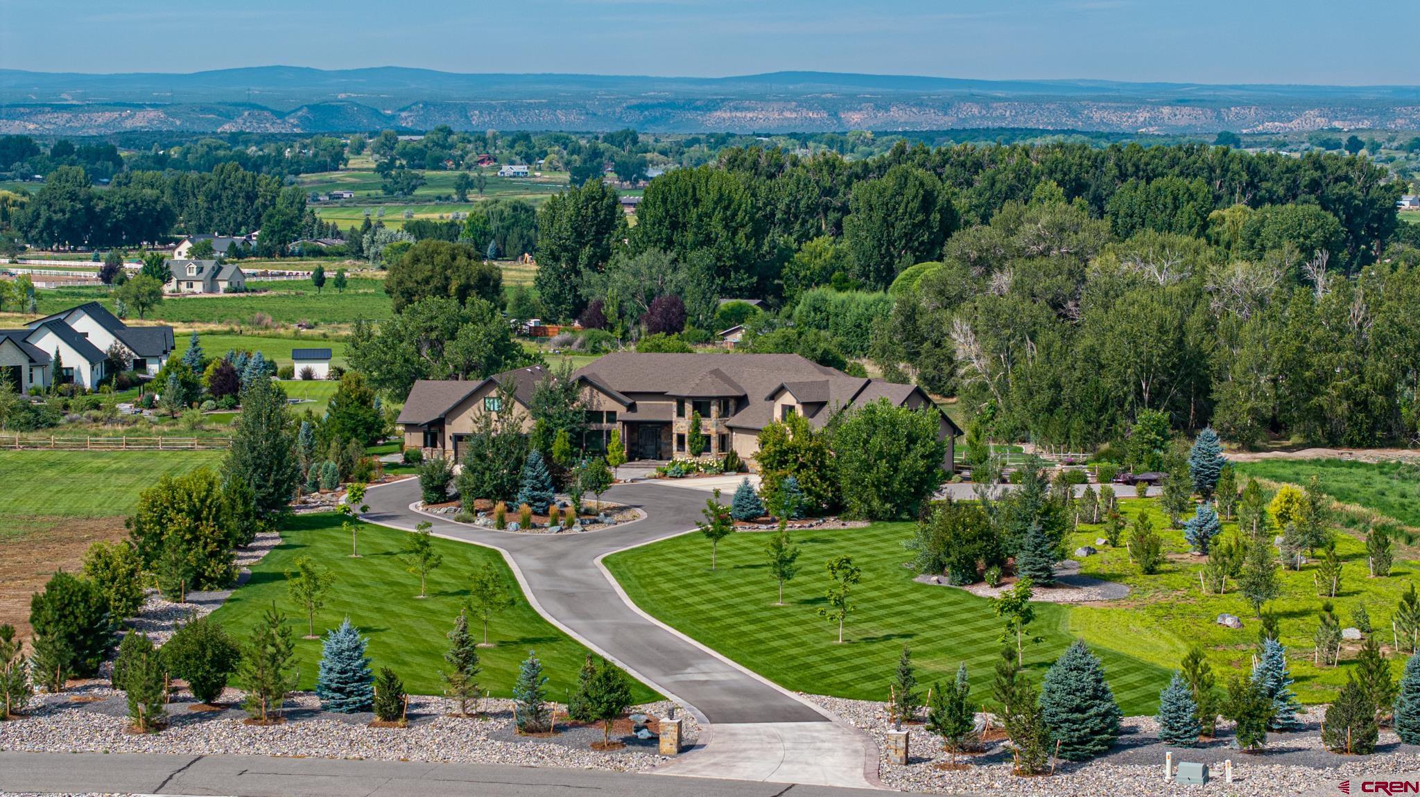 Montrose, CO Custom Luxury Home on 3 Acres with Creek Frontage   Welcome to one of the finest luxury homes on the Montrose market, offering nearly 7,000 square feet of spacious living in a timeless modern design. Situated on 3 beautifully landscaped acres, this 5-bedroom, 5.5-bath custom home was built in 2016 and is thoughtfully designed for multi-generational living, entertaining, and enjoying Colorado’s natural beauty. Spring Creek meanders through the back yard, offering a peaceful setting and a natural water feature right outside your door.  Located in the desirable Spring Creek neighborhood, just 3.7 miles from downtown Montrose, the property offers easy access to shopping, dining, and services—yet retains a quiet country setting surrounded by farms, ranches, and estate homes. It’s rare to find a home that blends elegant comfort, smart functionality, and high-end finishes with such a premium location.  Highlights:  6,796 total finished sq ft  5 bedrooms, 5.5 bathrooms  5 garage bays (some oversized)  Two large offices (one could be 6th bedroom)  Game room with wet bar  Full gym with roll-up door to back yard  2 laundry sets, laundry chute, pass-through  Mother-in-law suite w/ attached garage  3 irrigated acres with 90+ trees and pressurized irrigation system  Spring Creek frontage  $400/year HOA, includes landscaping water  Paved driveway, extensive landscaping (17-zone system)  Knotty hickory floors; knotty alder trim and cabinetry  Oversized granite countertops, butler’s pantry, high-end Kohler fixtures  Custom metal railings and dry-stacked stone fireplace  Covered outdoor living spaces along the creek  The main level includes an open-concept great room with a spacious kitchen and center island overlooking the living area, plus a butler’s pantry and a smaller study or media room. The primary suite features a luxurious 5-piece bath with steam shower and a large walk-in closet. On the opposite end of the house, a private guest or in-law suite includes its own living area, bedroom, and bath. Upstairs, three bedrooms each have an en suite bath, plus there's a powder room downstairs.  Additional features include a large mud room with built-in lockers, a custom-crafted staircase with iron railings, oversized garage bays for trucks or a workshop, and an engineered septic system. The home is serviced by Chipeta Water District and natural gas.  Lifestyle & Location: Montrose is a growing Western Colorado hub with a newly expanded regional airport offering flights to major cities. World-class outdoor recreation surrounds you: Black Canyon National Park, Gunnison & Uncompahgre National Forests, Telluride, Ouray, and more. Local amenities include a 75-bed hospital, a 80,000 sq ft rec center, performing arts venues, shopping, restaurants, and schools. Whether you're seeking a legacy home, multigenerational residence, or executive retreat, this Montrose custom property delivers it all.