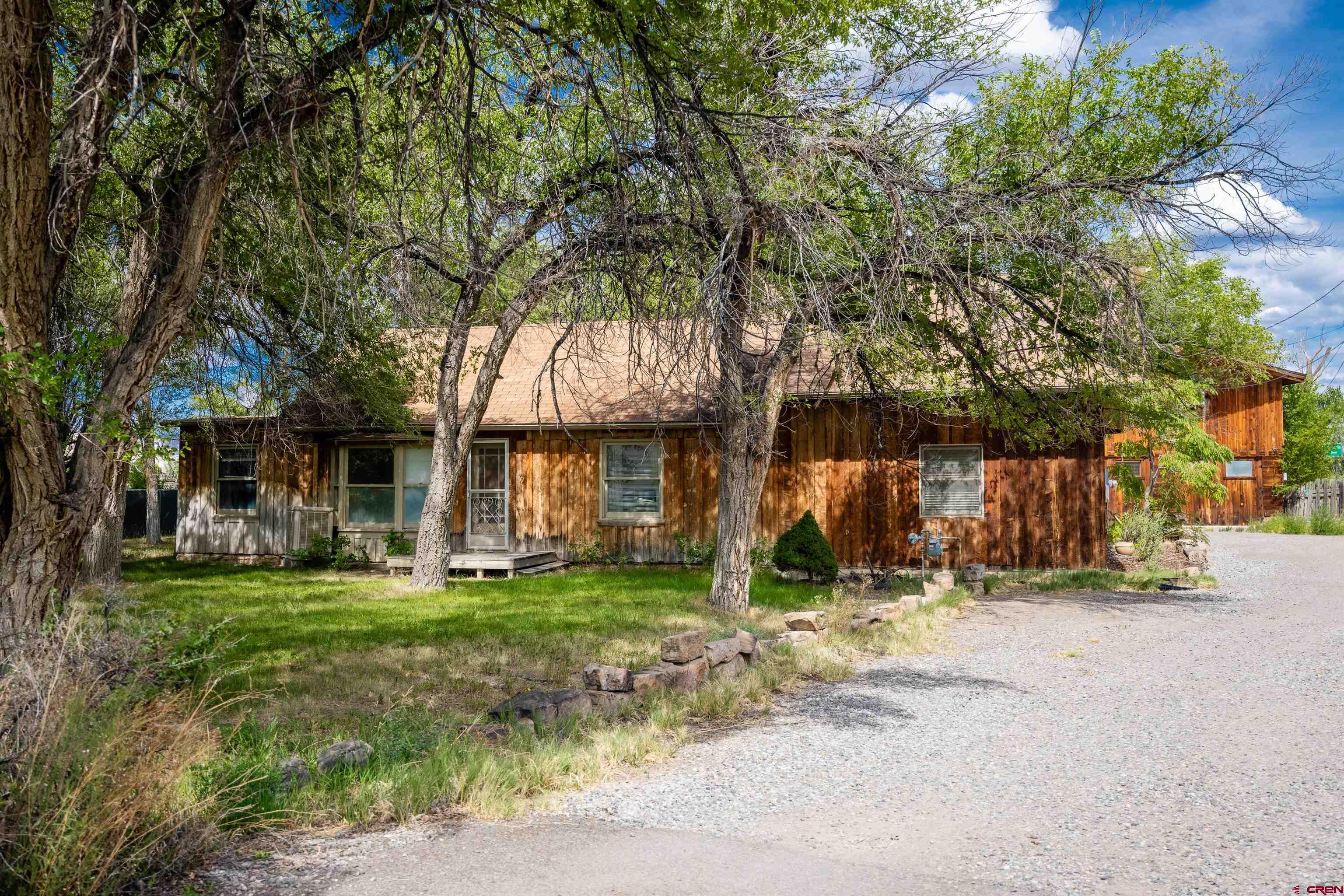 Welcome to 338 N Stough Avenue – a spacious and unique single-family residence located in central Montrose! This 3-bedroom, 2 ¾-bath home offers approximately 2,578 square feet of living space on a generous 0.572-acre irrigated lot. Originally built in 1939, the home retains its original charm while offering practical updates and an abundance of flexible living space.  Interior features include wood and carpet flooring throughout, a warm and inviting living area with a loft above, and a kitchen equipped with stainless steel appliances, wood cabinetry, and wood countertops. Bathrooms include a functional Jack-and-Jill style bath/laundry combo, a primary suite with direct access to the outdoors, and a recently updated bathroom in the detached studio.  The converted garage has been thoughtfully transformed into a self-contained studio apartment—complete with a full kitchen, bath, and lofted sleeping space- ideal for guests, extended family, or potential rental use (verify with city/county zoning and regulations).  The exterior offers a large irrigated lawn, established green space, a hot tub, patio area, and ample parking with a gravel driveway. A workshop/storage area is attached to the studio, providing added functionality.  Conveniently located near downtown Montrose, Montrose Fairgrounds, local parks, schools, public transportation, and restaurants- this home offers both privacy and accessibility.  This is a rare opportunity to own a versatile property with space, comfort, and future potential.  - Contact your REALTOR® to schedule a private showing today!  Fair Housing Disclaimer: This listing is presented in accordance with the Fair Housing Act and is not intended to discriminate on the basis of race, color, religion, sex, disability, familial status, or national origin.