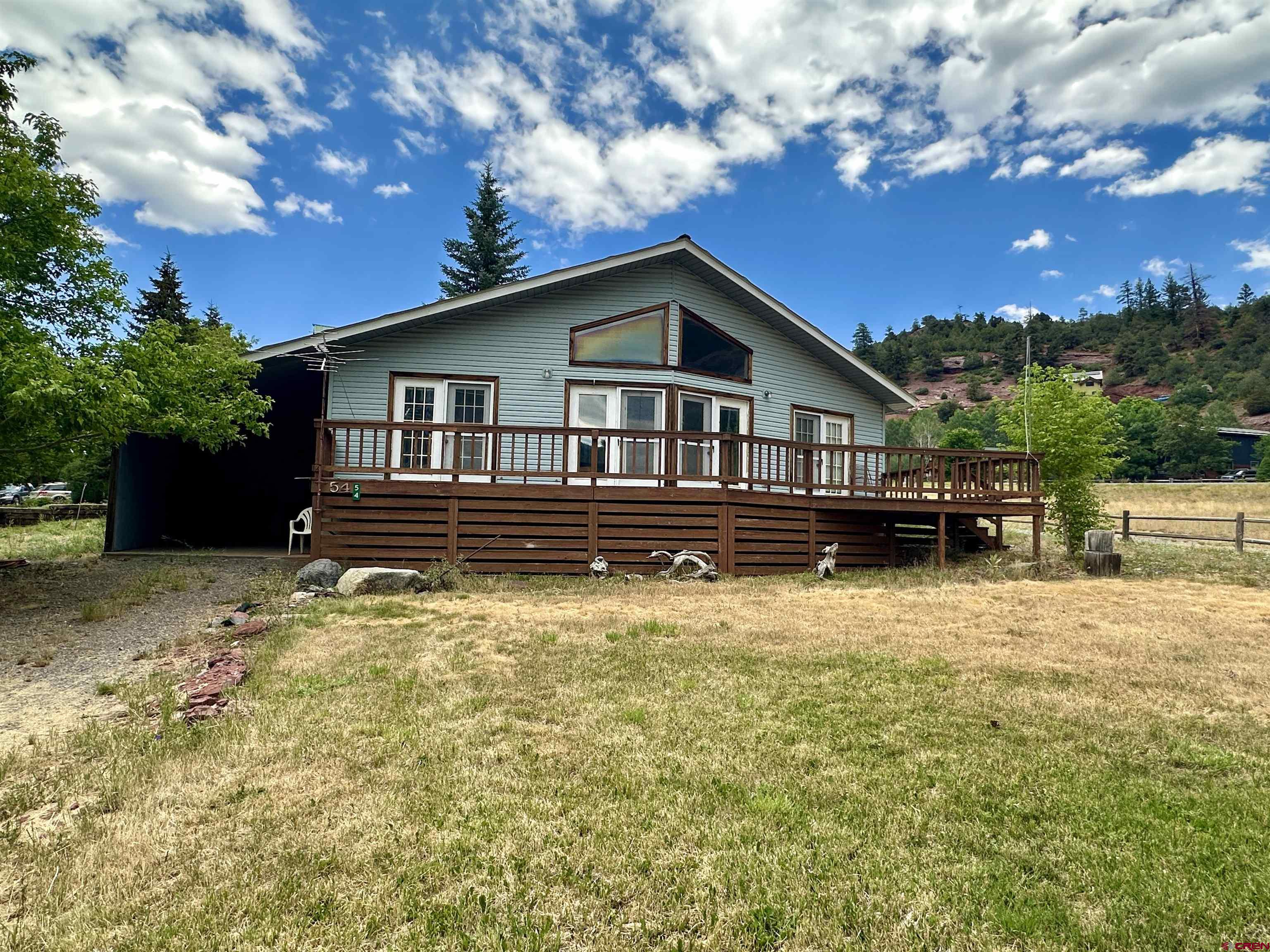 Perched on a corner lot in the desirable Panoramic Heights subdivision, this 3-bedroom, 2-bath home offers incredible views of Mount Abrams and overlooks the picturesque town of Ouray. The home features a split floor plan and high ceilings that make the layout feel open and inviting. A spacious deck extends the living area outdoors—perfect for relaxing above town or soaking in the mountain views. Practical features include a one-bay carport, a durable metal roof, and easy year-round access just five minutes from downtown Ouray. A dedicated laundry/mud room and ample storage are pleasant surprises in this home. Whether you're looking for a full-time residence or a weekend retreat, this property is a rare find in one of Colorado’s most iconic mountain communities. Come see the potential and make it your own.