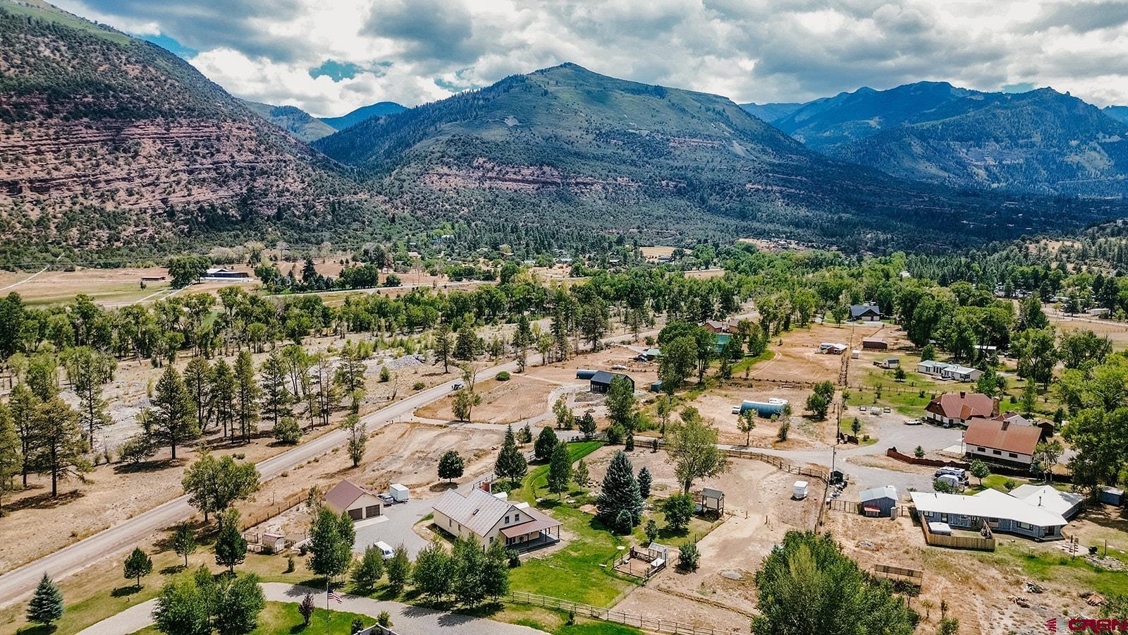Welcome to your western slope dream home with unobstructed mountain views! Nestled in the valley in between the quintessentially charming towns of Ouray and Ridgway, this versatile home combines rustic charm with modern upgrades—offering comfort, function, and room to grow.  Home Features: 3 Bedrooms / 2 Bathrooms, including a remodeled full bath and a primary suite with a wood stove and walk-in closet Expansive dormered upstairs bedroom with cubbies, built-ins, and a full upstairs bath Remodeled laundry/mud room for added convenience Engineered hardwood flooring, new carpet in the downstairs bedroom, and built-in shelving Vaulted tongue-in-groove ceiling and a second cozy wood stove Efficient on-demand hot water and hot water baseboard gas heating  Outdoor Features: Fenced and cross-fenced for animals—perfect for horses, chickens, and sheep Includes chicken coop, sheep pen, and horse setup with electric fencing Pond with irrigation water, charming meandering ditch through the property, plus a fire pit for year-round enjoyment Greenhouse  Brand new engineered exterior covered wrap around deck!  Irrigation via ditch and pump system: 2” pump pulls irrigation water (no flood irrigation) Pump also connected to sprinkler system  Extra perks: cherry tree, playhouse, and even a motorcycle track (can be leveled)