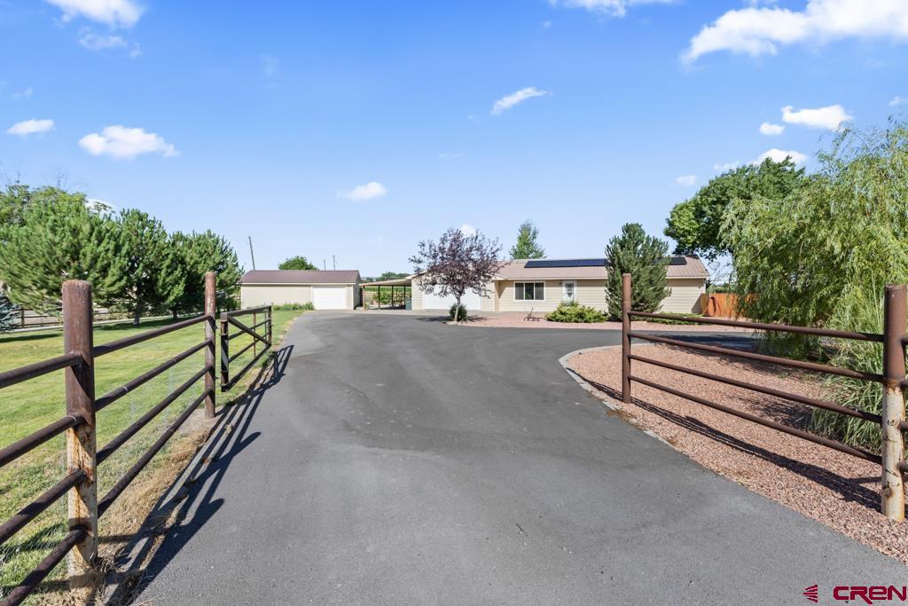 If you are looking for a quiet rural setting yet close to town, this single level 3-bedroom, 2 bath home on 1.47 irrigated acres is for you. Open concept floor plan with beautiful custom wood cabinets and island with granite counter-tops open to the large living and dining rooms.  Separate laundry room and mud room. New windows and a new Solar System has been installed, taking your monthly electric bill down to around $33/month!! Large trex deck off the dining area with to enjoy the unobstructed views. The detached workshop with 220 amp service has a separate finished room used for meat processing with an attached commercial walk-in cooler and 125 amp service. The whole property is fenced with pipe fence and the circular driveway is paved. This is a perfect property for 4-H animals or anything you could dream of.  No covenants and no HOA!! Contact me to schedule a showing and make this this property your new happy home.