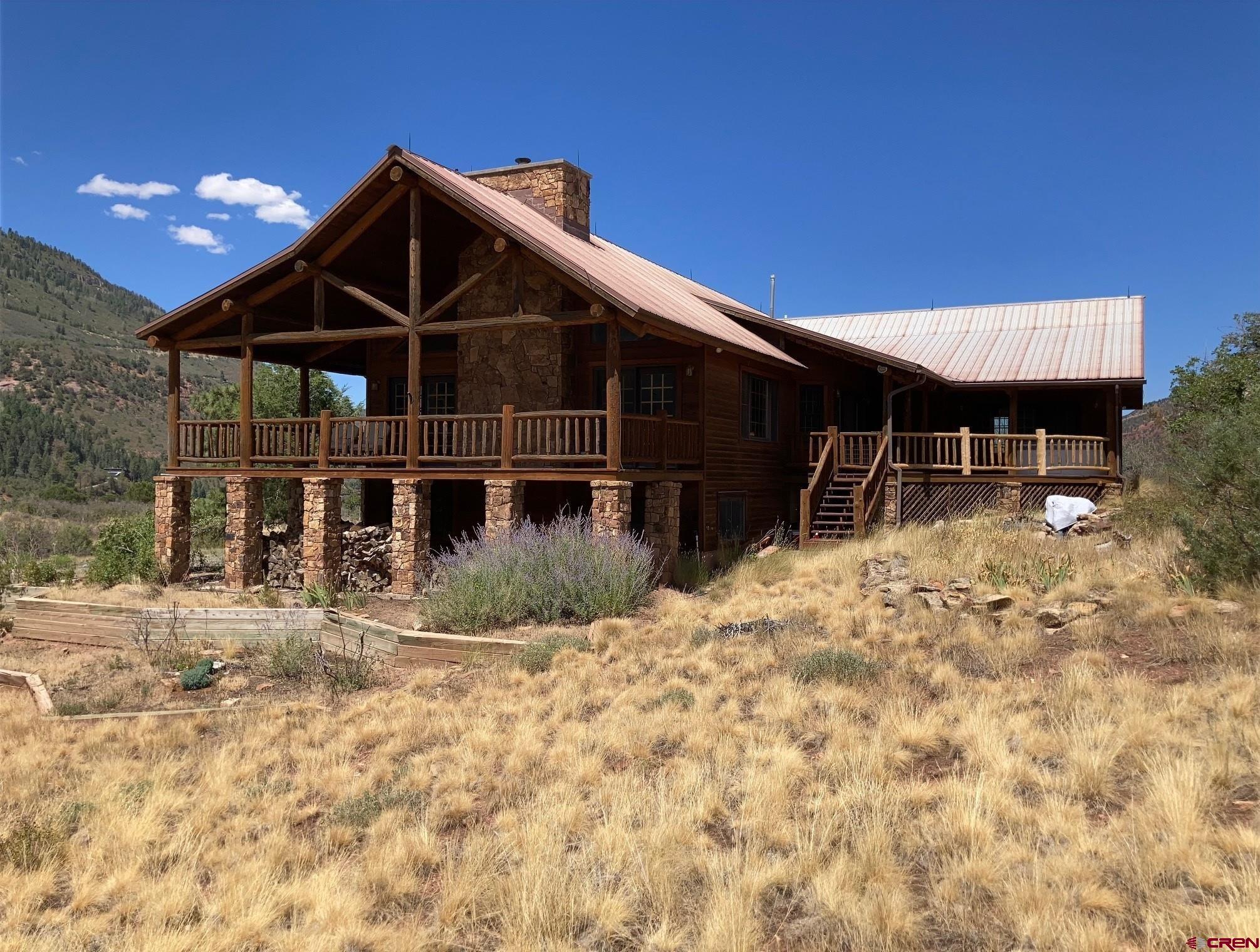 Nestled in the heart of the San Juan Mountains between Ouray and Ridgway, this rare Black Lake log-accent mountain home offers a once-in-a-lifetime opportunity to own one of only ten homesites in this private alpine community, where residents share 100 acres of pristine land, a stunning high-altitude lake, walking trails, and a serene park for kayaking, fishing, and outdoor gatherings. Perfectly positioned on one of the most desirable one-acre parcels, the home captures breathtaking southern views of Ouray, Mount Abram, and the surrounding peaks, with hand-scraped log beams, tongue-and-groove ceilings, a floor-to-ceiling stone fireplace, and expansive covered decks that create over 1,200 square feet of year-round outdoor living space. The gourmet kitchen, custom cabinetry, and open-concept great room are ideal for entertaining while enjoying panoramic lake and mountain views, while the primary suite and guest rooms offer comfort and privacy for family and friends. Additional space includes a 900-square-foot lower-level unfinished but heated room—ideal for a game room, workshop, or extra bedrooms—and a spacious west-facing garage perfect for gear and Colorado projects. Ownership here is more than just a home: it includes 10% shared ownership of Black Lake and its surrounding 100 acres, a conservation-style community that protects the beauty of the San Juans while offering a rare lifestyle of boating, hiking, wildlife watching, and true alpine serenity. Just minutes from Ouray, Ridgway, and a scenic drive to world-class skiing in Telluride, this exceptional Colorado log-style retreat is a dream for those who love the mountains, adventure, and the authentic Rocky Mountain lifestyle.