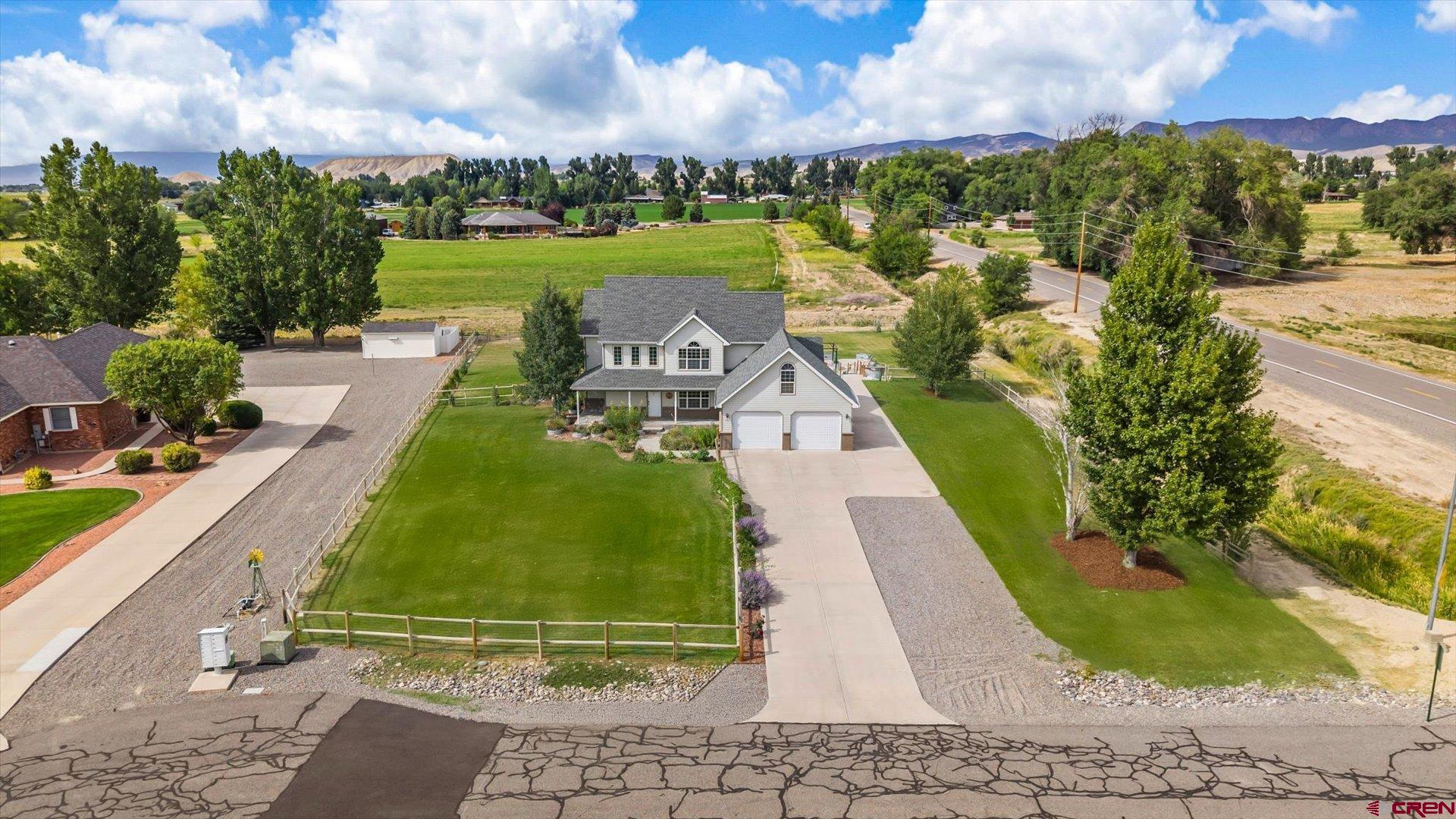 A Rare Opportunity in One of Montrose’s Most Sought-After Neighborhoods! This custom-built home sits on 1.36 irrigated acres with no HOA —a true find in today’s market. The current owner has transformed the property into a welcoming retreat with lush landscaping, mature trees, vibrant flower beds, even a fruitful grapevine that produces mounds of grapes, plus a charming front fence with gated entry. The Mountain Views are spectacular from the backyard sitting area, turned Sanctuary. Inside, thoughtful upgrades enhance comfort and style, including brand-new hardwood floors throughout, all new appliances, new blinds, and an energy-efficient tankless water heater. For added convenience, the property is equipped with 220 power for a hot tub and a 30/50 amp hookup for your RV. The spacious backyard is fully fenced, equipped with a sprinkler system, and bordered by open space views—perfect for entertaining, relaxing, or simply enjoying the Colorado outdoors. A poured concrete pad with plumbing stub-out is ready for your vision, whether that’s a shop, studio, or home office. The home itself offers timeless quality with features such as a covered front porch, backyard patio, main floor primary suite, central vacuum system, radon mitigation system, bonus room over the garage or second-floor flex room. Storage abounds, making this home as practical as it is inviting. Conveniently located near the Montrose Recreation Center, shopping, restaurants, schools, and medical services, this property combines privacy, space, and accessibility. Do you know what the biggest BONUS is? There is  irrigation water available for just $35/year, making maintaining this incredible property both easy and affordable! This property has been lovingly updated and cared for—making it ready for you to step right in and enjoy.