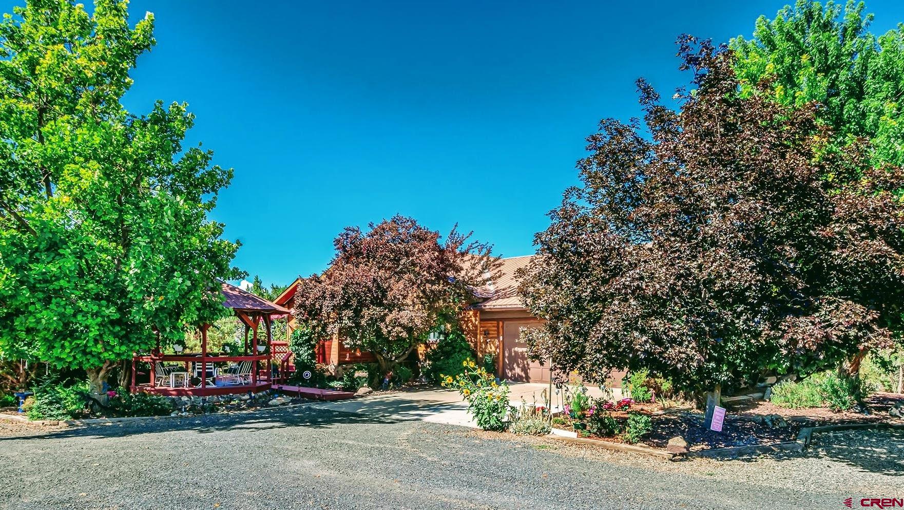 LUXURY COUNTRY ESTATE IN CEDAREDGE WITH 2+ RENTALS FOR EXTRA INCOME! Nestled in the Serene Mountain Valley of Cedaredge, Colorado, this Extraordinary Estate Spans Nearly 12 Acres of Peaceful Countryside, offering a Perfect Blend of Luxury and Tranquility. The Centerpiece of the Property is a Magnificent Quality Built Cedar-Sided 3940 SF Main Home, Thoughtfully Designed to Maximize the Breathtaking Panoramic Views of the Surrounding Mountains and Valleys. Expansive Decks Wrap Around the South & West Sides of the Home, Providing Ample Space to Soak in the Scenery, whether Enjoying a Quiet Morning Coffee or Savoring Evening Cocktails and the Stunning Colorado Sunsets, or Bask & Relax in the Shade of the Cool Enchanting Gazebo (a Popular Intimate Gathering Place) that Greets You at the Front Entrance of the Home Any Time of Day. Upon Entering the Home, You’ll find a Warm & Inviting Interior that Perfectly Complements its Mountain Setting. The Walls & Ceilings are Adorned with an Abundance of Knotty Pine Tongue & Groove Paneling, Showcasing the True Essence of a Colorado Mountain-Style Home. This Rustic Charm is Further Enhanced by Exquisite Custom Stained Glass, thoughtfully Integrated into the Doorways and Kitchen Cabinets, Adding a Touch of Artistry & Elegance throughout the Home. The Combination of Natural Wood and Intricate Stained Glass Creates a Rich, Cozy Atmosphere, Making Every Room in this Spacious Residence a True Retreat. In Addition to the Main Residence, the Estate Boasts Two Charming Smaller Homes, Currently Rented Out for Additional Income. These Versatile Spaces can Easily be Repurposed for Accommodating Guests or Extended Family. The Property Also Features Fertile Farmland with Good Irrigation Water, Making it Ideal for Agricultural Pursuits. Located in a Peaceful, Idyllic Setting, this Wonderful Country Estate Offers the Best of Both Worlds—Seclusion and Quiet Country Living, yet Conveniently Close to the Charming and Trending Town of Cedaredge, where You’ll find a Welcoming Community and All the Amenities you need. You will also be on the South Slopes of the Grand Mesa, the Largest Flat-Topped Mountain in the World, with Over 300 Lakes & Reservoirs, Boasting One of the Best Nordic Ski Areas in the World, Downhill Skiing, Snowmobiling, ATVing, Fishing, Camping, Hiking and Hunting. This Estate is More than a Home; it’s a Lifestyle of Luxury, Outdoor Sports & Activities, and Tranquility in One of the Most Beautiful Colorado Mountain Valleys You Will Ever See!