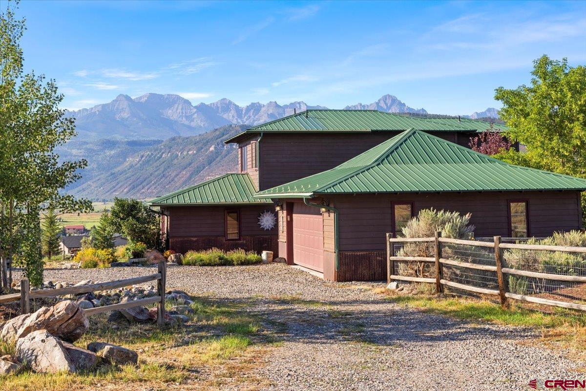 Set on a one-acre corner lot in coveted Vista Terrace Estates, this remodeled 4-bed, 3-bath home delivers the kind of San Juan and Cimarron views people move to Ridgway for!  Wide-angle panoramas that sweep across the Ouray Valley and fill nearly every room. The open great room frames the scenery from the kitchen and dining areas, while the updated kitchen features a large granite sink, concrete counter tops, and new stainless appliances. On the main level, a spacious bedroom opens to a beautiful patio with a salt water hot tub overlooking town and the peaks; a second en-suite bedroom soaks up the same dramatic vistas.  A custom "catio" will keep your pets safe from any predators.  Upstairs, the primary suite adds a sitting to a private deck perched above Ridgway. Engineered hardwood floors run throughout; comfort comes via hot-water in-floor heat in the great room and hot-water baseboard elsewhere. The on demand water heater is amazing!   Outside, enjoy a salt water hot tub, flagstone paths, garden space, a stamped-concrete patio with fire pit, and a fenced dog area. Trees were carefully planted to enhance privacy.  A 2-car attached garage offers a workbench and storage, and a ground-mounted ~3 kW PV solar array helps keep utilities in check. All of this in a close-to-town location.  Contact us for a private tour today!