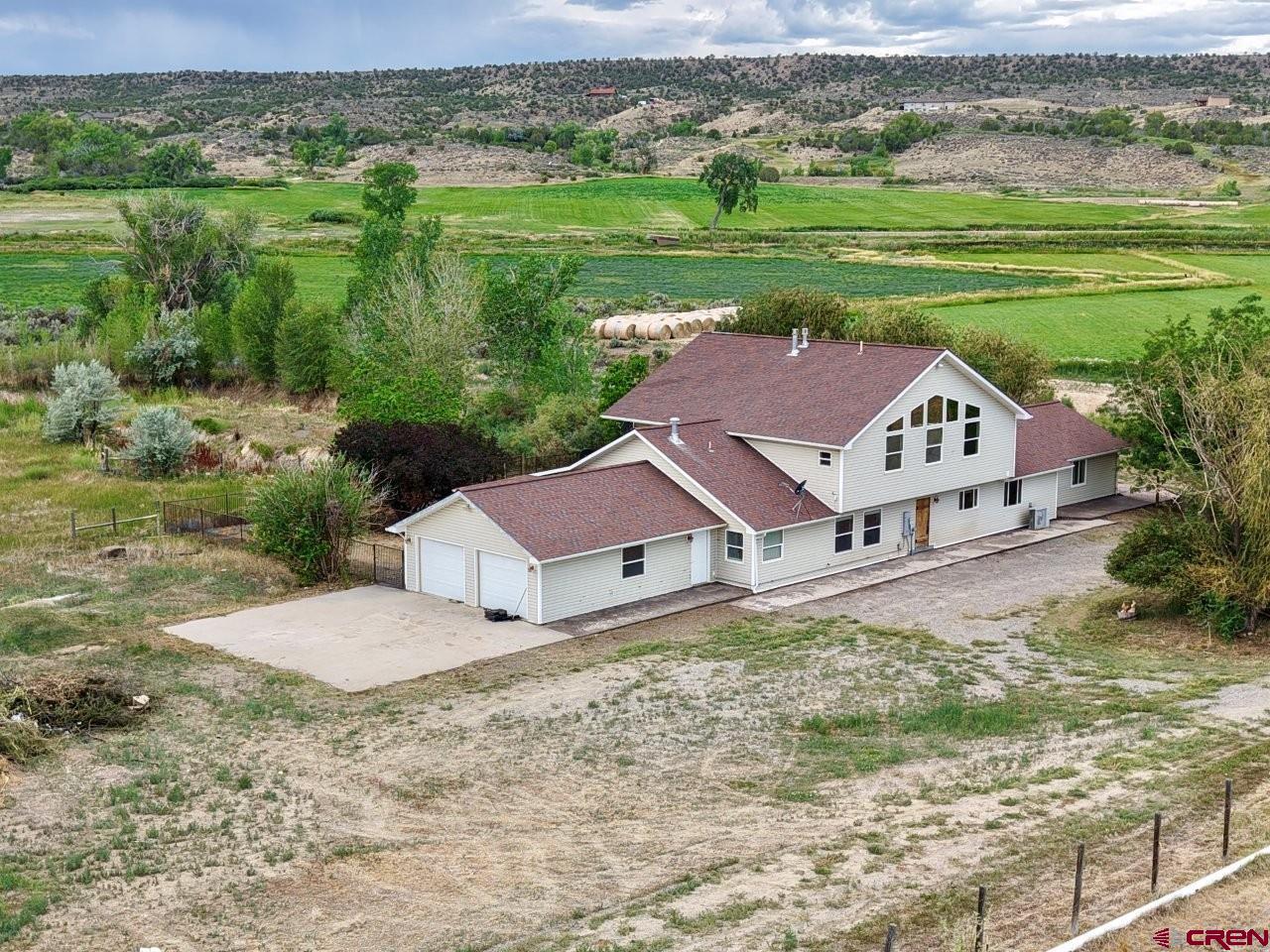Spectacular horse property set up south of Montrose on 43.5 irrigated acres. With some TLC this horse ranch can be returned to a gem of a property.  This amazing and private location is bordered by Dolores Creek on the west boundary and boasts views of the beautiful San Juan Mountains.  The 85’x36’ horse stable features 10 stalls with 6 attached runs, waterers in each stall, tack room, covered front porch, and office that includes a ¾ bathroom and washing machine hookup. There is a breezeway connecting the stable to the 72’x48’ equipment shed with power and concrete floor. The 300’x225’ arena located just north of the stable has hosted many horse show events in the past. There are several horse pastures near the stable and arena. The property also boasts large flat fields ready to return into hay fields or make it what you want with the underground water delivery system. The 2 greenhouses and a small portion of the irrigated pipe still remain on the property. The home offers 4 bedrooms and 4 bathrooms that include two separate master suites. The main living area is ideal for entertaining and includes a large kitchen with island and bar seating, with tall ceilings, fireplace and sun filled south facing windows in the living and dining room area. The second floor offers two bedrooms, bathroom, a sitting area and fireplace. Relax after a long day out back on the rock patio, firepit, covered porch and horseshoe shaped pond.  The previous owners converted the two attached garages located on each end of the house into space for business purposes.  Continue to use as business or living space or convert back into garage space. There are so many possibilities for you to make this property what you want.