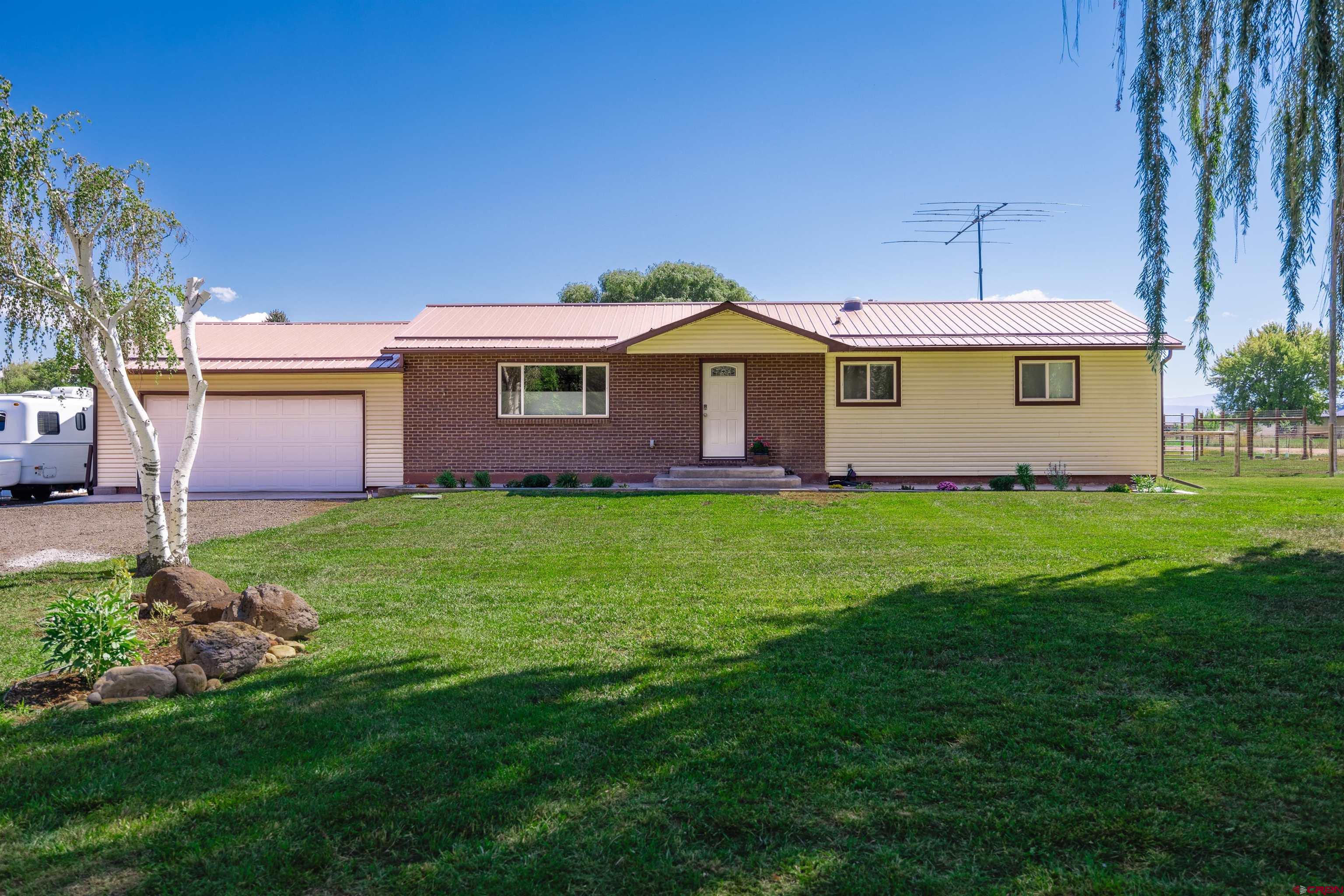 Welcome to peaceful country living on Spring Creek Mesa. This beautifully renovated 4-bedroom, 3-bath farmhouse offers 2,192 sq ft of updated comfort on 3 irrigated acres. Fully set up for horses, chickens, and more. Step inside to a warm, light-filled living room with a large picture window. The open kitchen features knotty Alder cabinets, granite countertops, a river rock backsplash, black stainless appliances, and eastern views. Two bedrooms include private en suites with custom tile showers, granite vanities, and rain glass doors. A versatile bonus room off the dining area offers flex space for a sunroom, family room, den, or home office. Solar tubes throughout the home add soft natural light. Outdoors, enjoy a fully functioning mini-farm with two fenced pastures, a horse shelter, hay barn, tack shed, chicken coop with auto door, four frost-free spigots, and a fenced orchard. Mature landscaping surrounds a large covered patio and a Trex deck with sunshade, perfect for entertaining. No HOA.