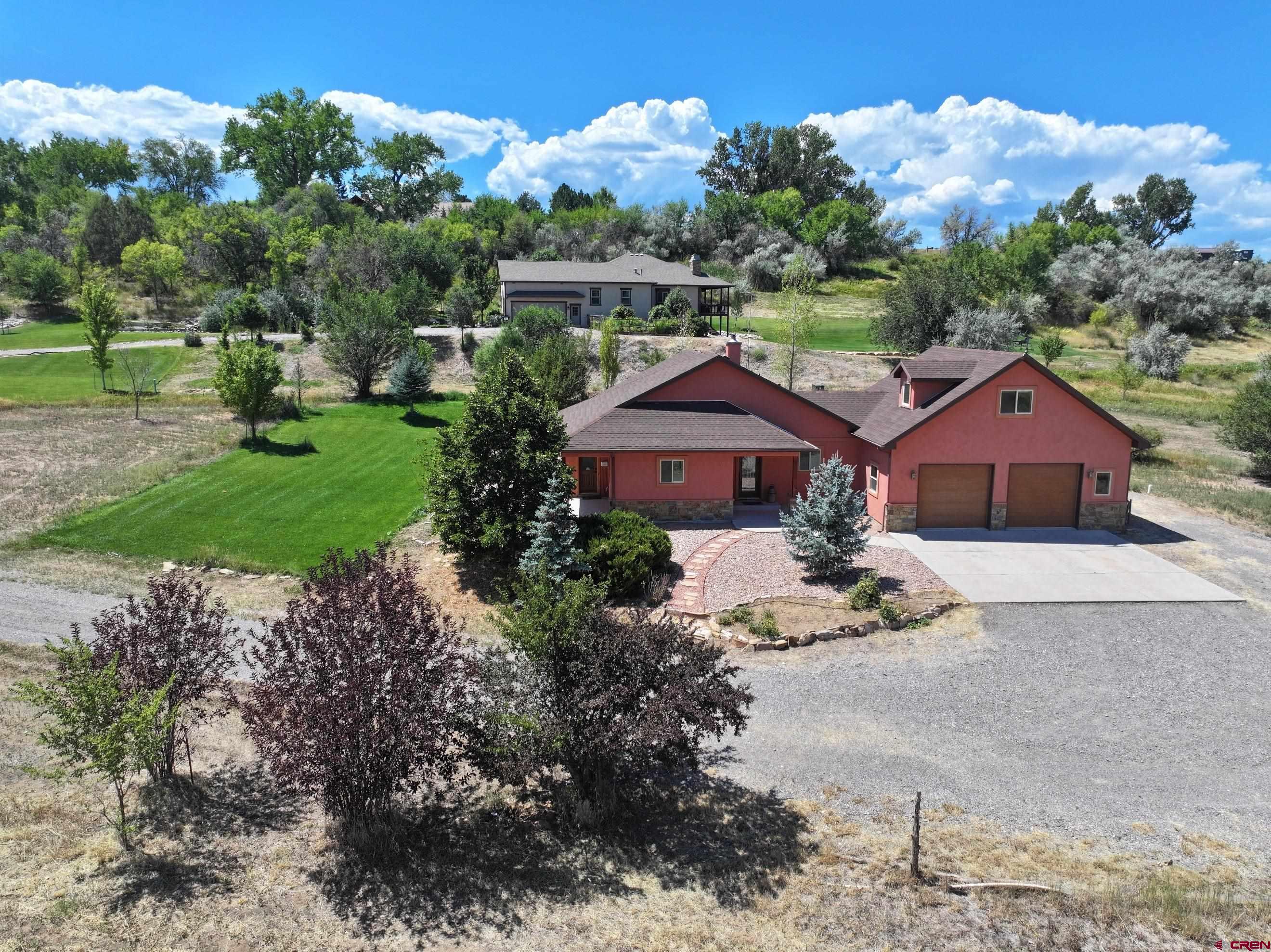 **With an acceptable offer, seller will pay up to $10,000 of buyer's closing costs at closing.**  This well-designed one-level ranch with a bonus room sits on three spacious acres southwest of Montrose. Showcasing a warm southwestern flair, this home has it all. Step into a welcoming tiled entryway that leads to a custom kitchen and a bright, south-facing living room. The kitchen includes all appliances, a generous pantry, cork flooring, and a cozy dining nook that connects seamlessly to the living area. The living room features beautiful bamboo flooring and a custom wood-burning fireplace, creating a cozy ambiance. A nearby office, bathed in natural light from its southern windows, can also serve as an additional bedroom. Across the hall, two inviting guest suites share a stylish southwestern-inspired bathroom. At the end of the hallway, the spacious primary suite enjoys abundant southern exposure and boasts two walk-in closets, dual sinks, a separate shower, and a charming clawfoot tub. Above the garage, a newly carpeted bonus room offers breathtaking views of the city lights and mountains—perfect as a recreation space or home office. Adjacent to the garage, the laundry room includes a convenient sink. This home has been freshly painted and features efficient geothermal heating and cooling. The beautifully designed southwestern-style Xeriscaping enhances its unique charm and saves water. Plus, with Elevate internet, working from home is a breeze. A true gem—don’t miss this incredible opportunity! some photos of this listing may include virtually staged amenities, furniture or fixtures.