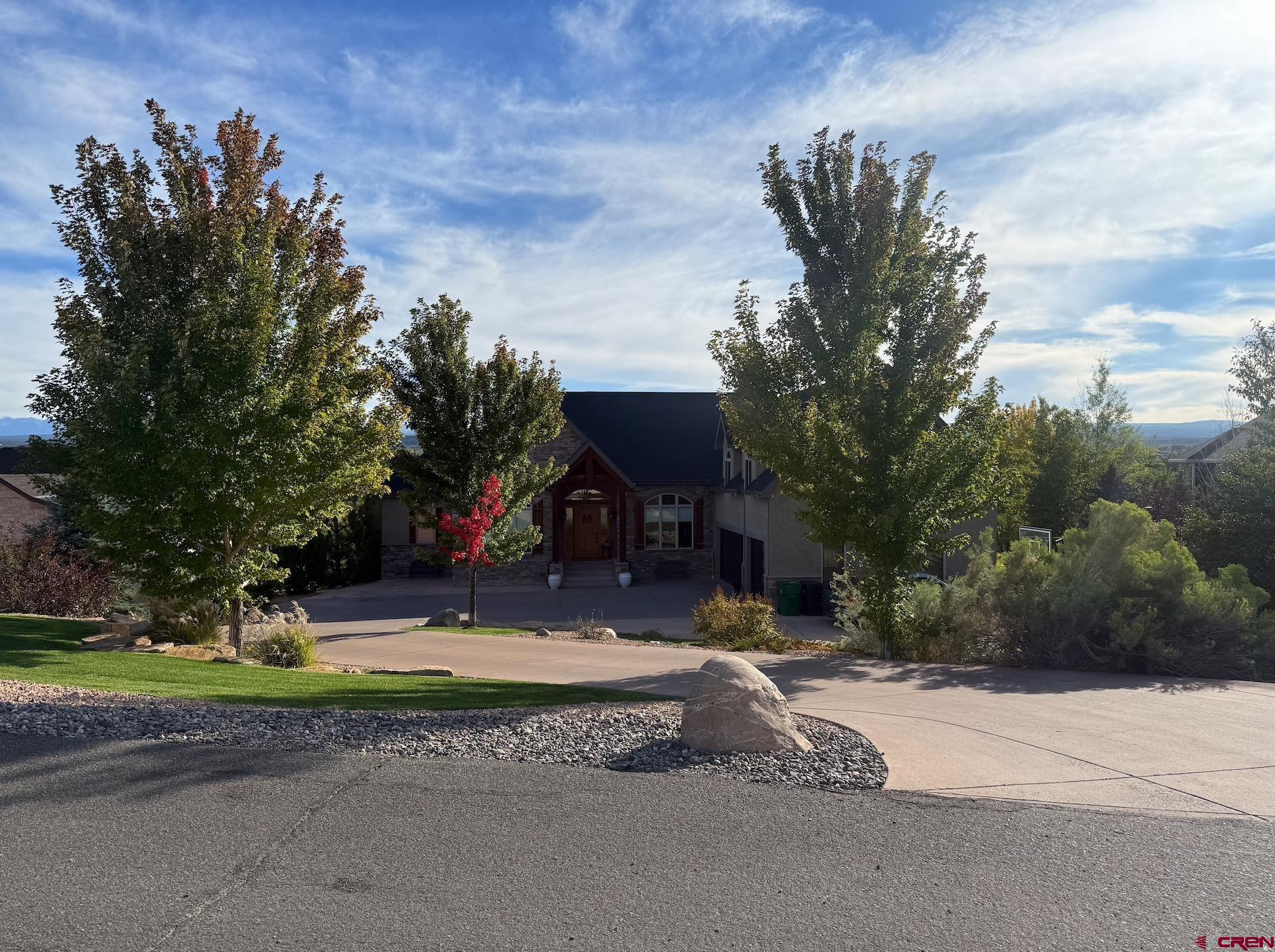 Nestled in the serene neighborhood of Friendly Hills, this stunning residence offers a rare blend of luxury, comfort, and breathtaking Colorado scenery. Set on a generous three-quarter-acre lot at the end of a quiet cul-de-sac, the home was thoughtfully designed to capture both elegance and warmth. Spanning more than seven thousand square feet, it provides ample space for family living and entertaining while maintaining an inviting and intimate feel. From the moment you enter, soaring ceilings and expansive windows draw your attention to the dramatic views of the San Juan Mountains and the lush wetlands that border the property. The heart of the home is its great room, anchored by a double-sided fireplace that seamlessly connects the living and dining areas. The gourmet kitchen is equipped with granite countertops, high-end stainless steel appliances, and a walk-in pantry, making it ideal for both casual family meals and large gatherings. The master suite is a private retreat, complete with a five-piece ensuite bathroom, a spacious walk-in closet, and the convenience of a dedicated laundry area. Downstairs, the walk-out basement extends the home’s living space with a huge home gym and a separate theater room, providing both fitness and entertainment without ever leaving the house. Above the oversized three-car garage, a versatile bonus room includes its own laundry facilities, making it perfect for guest quarters or multigenerational living. Every detail of this property reflects quality and craftsmanship, from the geothermal heating and cooling system to the thoughtful layout designed to maximize both functionality and beauty. Outdoor living is equally impressive, with a covered deck that frames unforgettable sunsets and provides the perfect setting for morning coffee or evening relaxation. Conveniently located near shopping, restaurants, walking and biking trails, the Montrose Recreation Center, and local schools, this home delivers both tranquility and accessibility. More than just a house, it is a lifestyle whether you envision energizing workouts in your private gym, movie nights in the theater, or the flexibility of multigenerational living with dual laundry spaces, this residence is ready to welcome its next chapter.