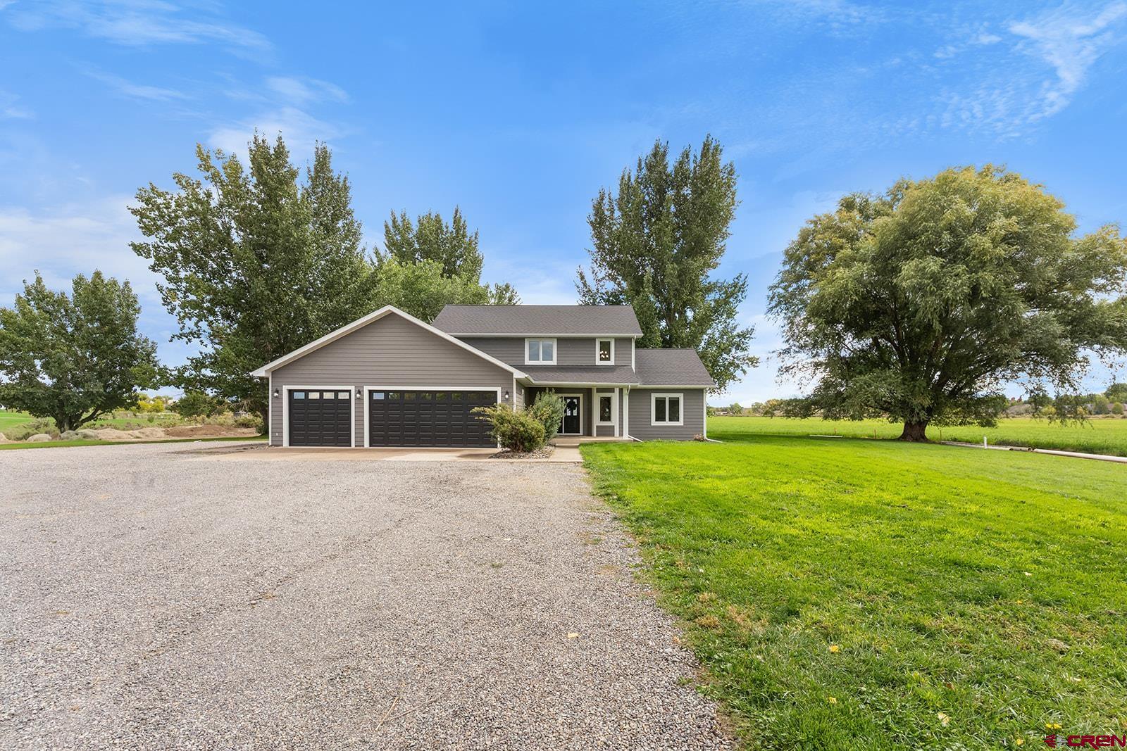 Spacious updated home in town on 1 acre with no HOA, no covenants, mountain views and a rural feel. Nearly 3,000 square feet of beautifully updated living space with 4 bedrooms, 2.5 baths residence offering large, light-filled rooms with gorgeous views in every direction, framed by mature trees and the surrounding mountains. The open kitchen is a dream, featuring brand-new stainless appliances, quartz countertops, tons of cabinets plus a pantry, and a kitchen bar that flows seamlessly into the large dining area, open to both the kitchen and the living room.   From the dining, step out to the expansive covered patio—perfect for year-round entertaining or simply enjoying the Colorado skies. The spacious main-level master suite is a true retreat with a luxurious ensuite that includes a tiled shower, soaking tub, double vanity, and a large walk-in closet. Upstairs, you’ll find three additional bedrooms, a generous family room, and a well-appointed bath with a tiled shower. The dedicated laundry room comes with a new washer and dryer, an adjacent half bath, and extra storage space to keep everything organized.  More storage space is afforded in the extra large entry closet and under stairs closet. A 3-car garage with keypad entry, plus room for an RV, trailer, or toys, ensures plenty of parking and storage. With no HOA or covenants, you also have the freedom to add a shop or customize the property to your needs. Located on the desirable south side of Montrose, you’re close to schools, shopping, restaurants, and the Montrose Recreation Center—yet the setting offers the peaceful feel of a rural retreat. This property combines space, style, and freedom in one incredible package. Don’t miss the chance to make it your next home!