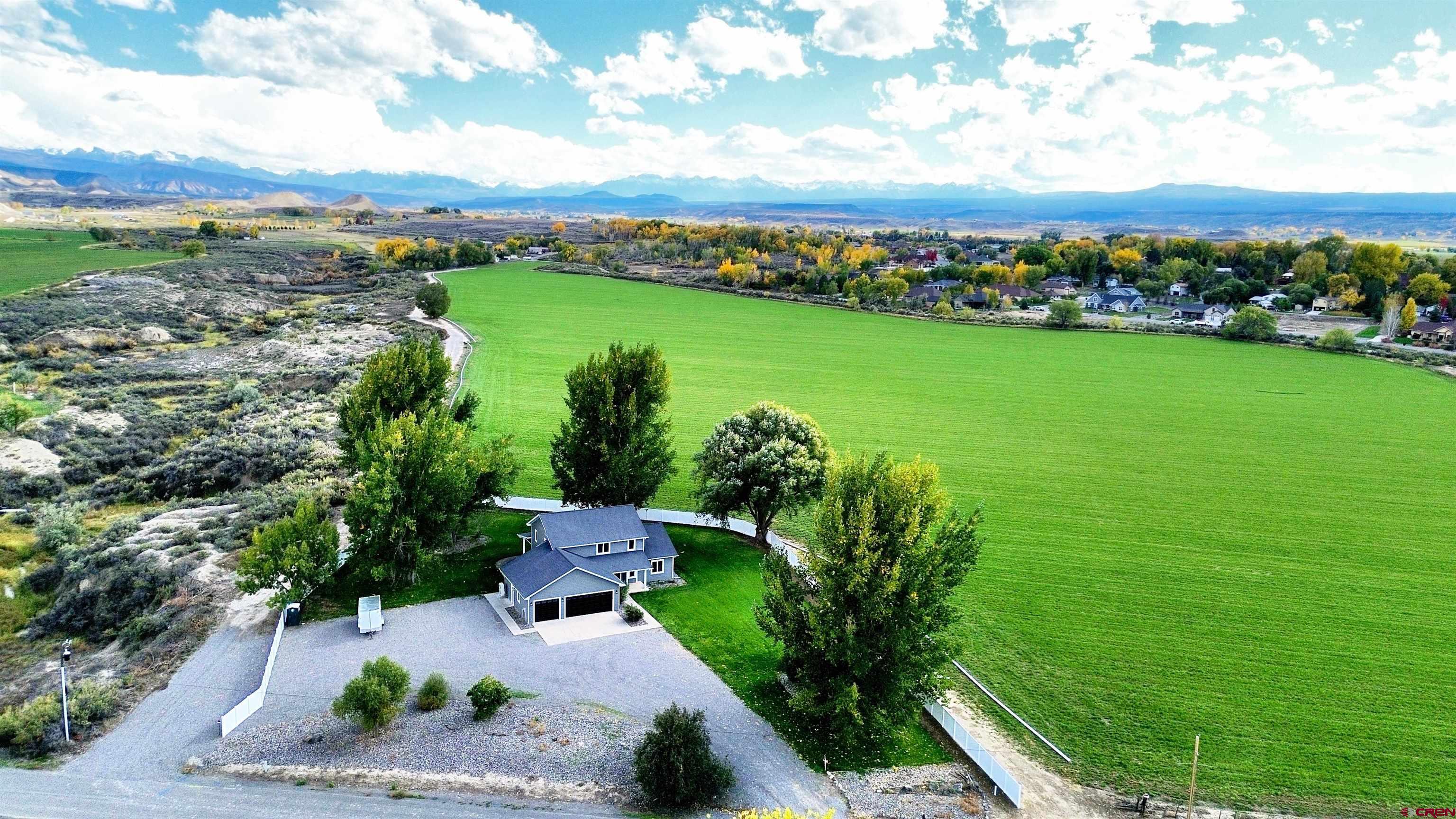 Spacious updated home in town on 1 acre with no HOA, no covenants, mountain views and a rural feel. Nearly 3,000 square feet of beautifully updated living space with 4 bedrooms, 2.5 baths offering large, light-filled rooms with gorgeous views in every direction, framed by mature trees and the surrounding mountains. The open kitchen is a dream, featuring brand-new stainless appliances, quartz countertops, tons of cabinets plus a pantry, and a kitchen bar that flows seamlessly into the large dining area, open to both the kitchen and the living room.   From the dining, step out to the expansive covered patio—perfect for year-round entertaining or simply enjoying the Colorado skies. The spacious main-level master suite is a true retreat with a luxurious ensuite that includes a tiled shower, soaking tub, double vanity, and a large walk-in closet. Upstairs, you’ll find three additional bedrooms, a generous family room, and a well-appointed bath with a tiled shower. The dedicated laundry room comes with a new washer and dryer, an adjacent half bath, and extra storage space to keep everything organized.  More storage space is afforded in the extra large entry closet and under stairs closet. A 3-car garage with keypad entry, plus room for an RV, trailer, or toys, ensures plenty of parking and storage. With no HOA or covenants, you also have the freedom to add a shop or customize the property to your needs. Located on the desirable south side of Montrose, you’re close to schools, shopping, restaurants, and the Montrose Recreation Center—yet the setting offers the peaceful feel of a rural retreat. This property combines space, style, and freedom in one incredible package. Don’t miss the chance to make it your next home!