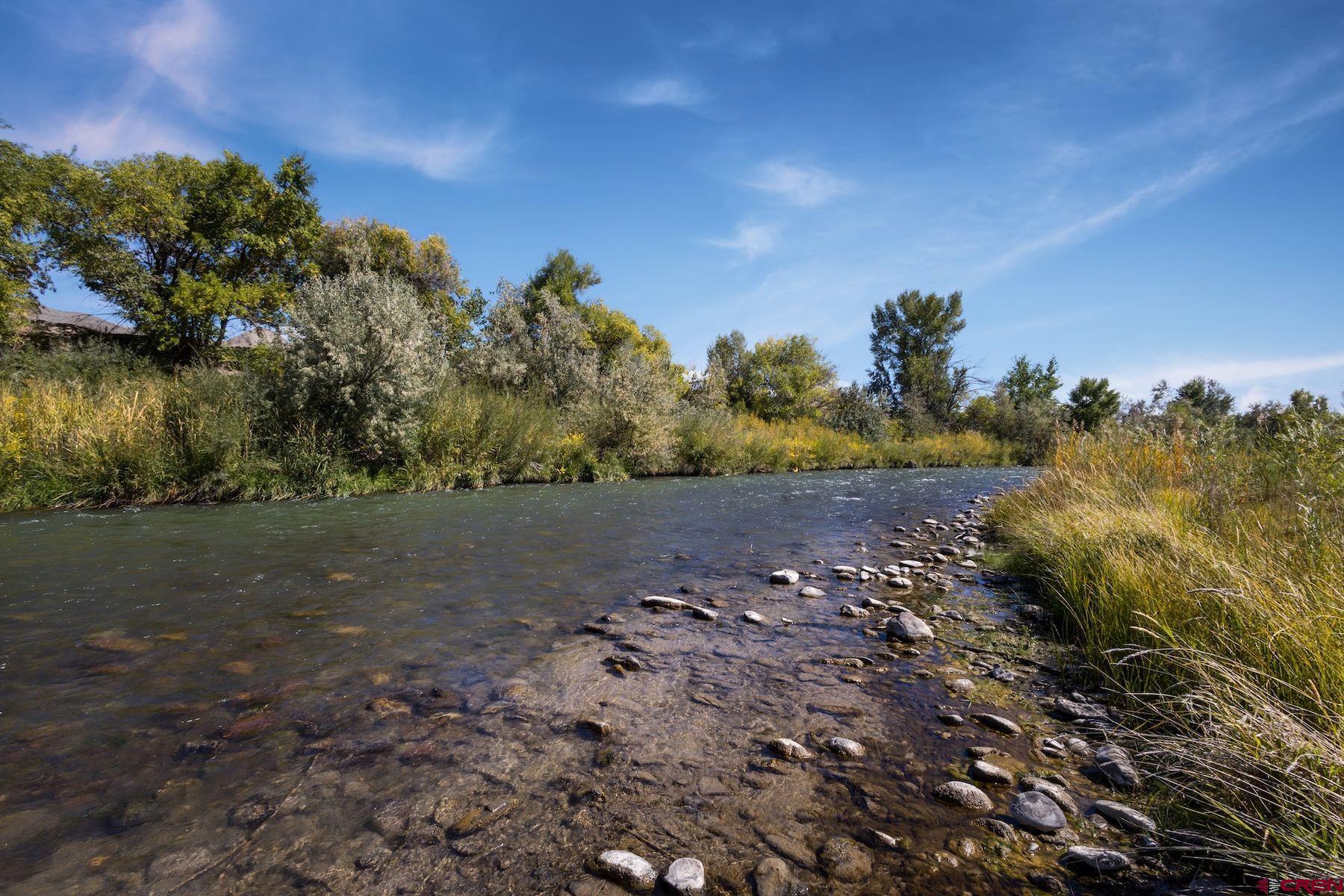 Rare 10-acre property with 1/4 mile of Uncompahgre River frontage offering excellent fishing right on your land. Zoned commercial or residential, it features a farmhouse, shop/warehouse, detached garage and six full-service RV/tiny home sites with room to expand. With abundant water, established infrastructure, and a special use permit, this property offers endless opportunities.