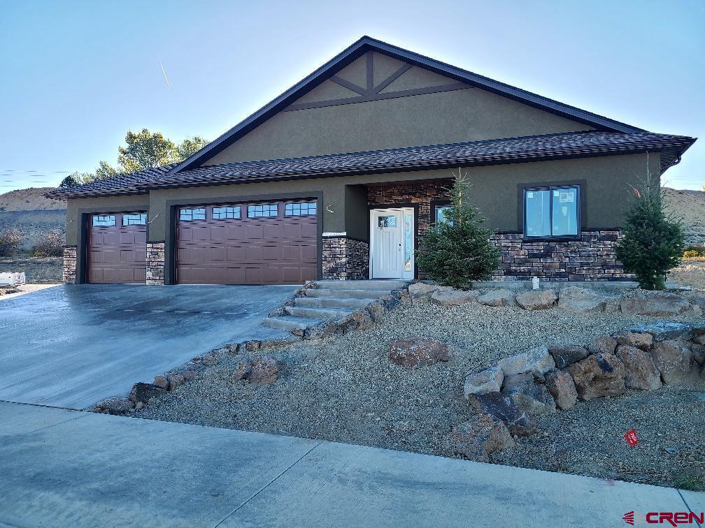 Stunning New Construction – 4 Bed | 3 Bath | 3-Car Garage Wood’s Crossing Subdivision | Built by Uncompahgre Valley Builders, LLC  Welcome to your future home in the sought-after Wood’s Crossing Subdivision, where quality craftsmanship meets modern design. Built by local favorite Uncompahgre Valley Builders, LLC, this thoughtfully designed 4-bedroom, 3-bathroom home offers 2,318 square feet of beautiful living space and backs to open space for added privacy and serenity.  Key features include:  Oversized 3-Car Garage with premium Martin Garage Door  Andersen 100 Series Composite Windows and Doors for energy efficiency and durability  Spacious Open Floor Plan with vaulted ceilings and a floor-to-ceiling natural stone gas fireplace  Kitchen equipped with American Woodmark cabinetry – 42” upper cabinets with under-cabinet lighting, soft-close technology, and pull-out trays in the lower cabinets  Quartz Countertops throughout, including a stunning 10-foot island with seating for six  Interior finishes were selected with both style and functionality in mind:  Luxury Vinyl Plank (LVP) Flooring in living, dining, kitchen, and hallway areas  Tile Flooring in all bathrooms and the laundry room  Primary Bathroom featuring electric in-floor heating, a 36” soaking tub, floor-to-ceiling tiled shower with European-style glass door  Guest Bathroom also offers tiled shower walls from tub to ceiling  Solid Core 36” Doors on all bedrooms and bathrooms for added sound insulation and quality  Outdoor living is just as impressive:  Covered Front Porch with an 8’ x 28’ concrete seating area  Expanded Rear Patio measuring 14’ x 14’, featuring Colorado Blue Stain Pine (Beetle Kill) ceilings  Construction is already underway—don’t miss the opportunity to own a brand-new, beautifully appointed home in one of Montrose’s most desirable communities.  Contact us today for more details or to schedule a site visit. This home won’t last long!