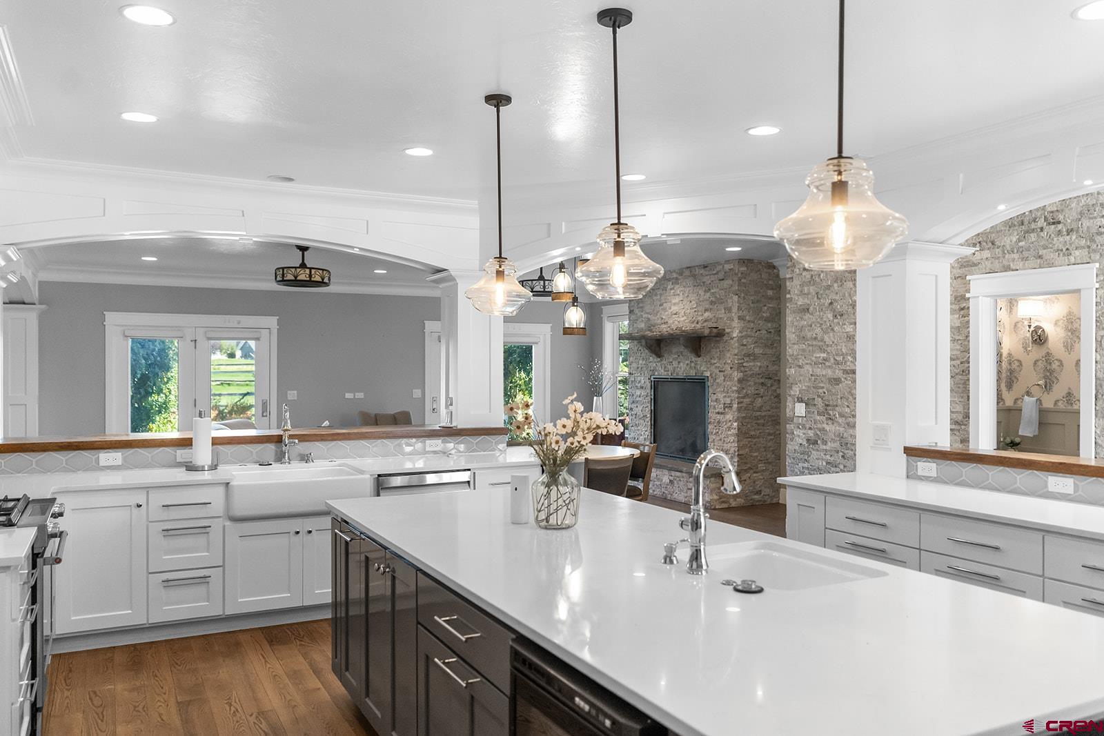 Experience the finest in luxury living and timeless craftsmanship with this extraordinary custom home perfectly positioned on the golf course in Cobble Creek. From the moment you step inside, every detail speaks of elegance and quality. Graceful archways frame the gourmet kitchen designed for both style and function. An expansive island, striking designer lighting, stainless steel appliances—including a gas range top, wall oven, microwave, refrigerator, and wine fridge—make it a chef’s dream. A casual dining bar, walk-in pantry, and additional hall cabinetry add convenience and storage in abundance. A stone accent wall leads you to the impressive great room with dual ceiling fans and a warm gas fireplace beneath a custom mantel. A formal dining area with wainscoting and adjacent built-in display cabinetry provides a perfect space for entertaining in style. The spacious main-level primary suite is a private retreat with a spa-like bath featuring separate vanities, a jetted tub, oversized tiled shower, private toilet, a large walk-in closet plus additional closets. The split floor plan includes two additional bedrooms and a full bath on the main level, along with a powder room for guests. A thoughtfully designed laundry room includes cabinetry and a utility sink. Upstairs, a large family room with deck access captures panoramic views of the course, pond, and the majestic Colorado mountains beyond. A west-facing balcony offers additional outdoor living, while a finished flex/storage room adds functionality. French doors off the living room open to a patio and a beautifully landscaped, fenced backyard complete with raised garden beds and a full sprinkler system. The three-car garage offers an additional utility sink and plenty of space for vehicles and gear. Modern comforts include forced-air gas heat, central air conditioning, and a central vacuum system. This stunning Cobble Creek residence is more than a home—it’s a lifestyle of luxury, comfort, and Colorado beauty.
