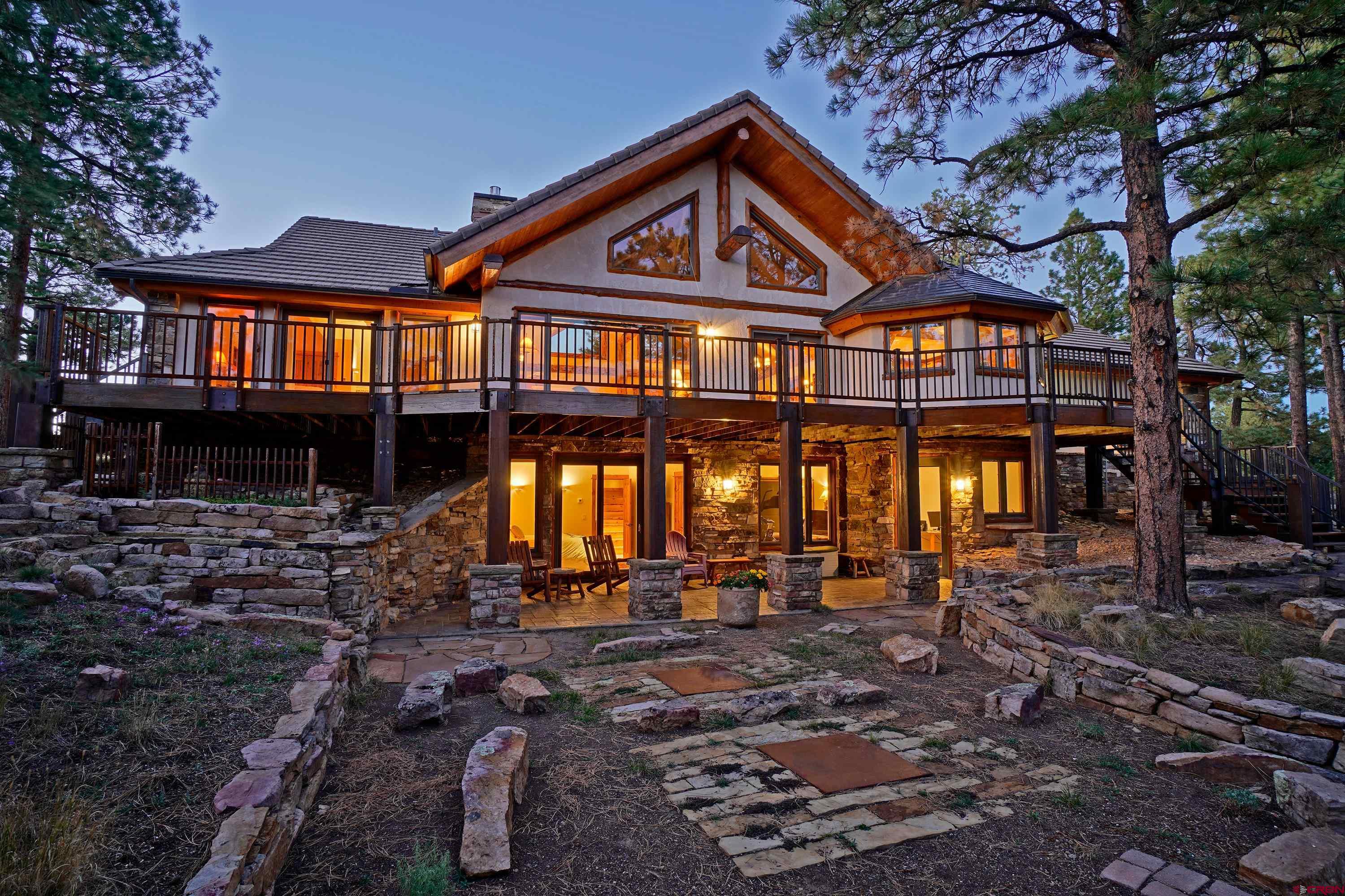 WOW!  Look at every other property in Ouray county at this price point before viewing this one.  You'll quickly discover why!  Immaculately maintained would be an understatement.  Even though the property is listed as 2 bedrooms, the lower level workout room and media/office room could easily be used as a large 3rd bedroom with the existing closet and easy entry/exit.  Check out the 3-D tour for a virtual walkthrough of this amazing property. Upon approaching the front door, it should be noted that it is hickory and was handmade by an artist/craftsman from Montrose. After entering the front door, you'll notice the wonderful great room details to include both slate and hardwood oak flooring, tongue and groove aspen ceiling, stone fireplace from floor to ceiling, and timbers that were brought in from Utah.  From the great room, you can enter the well laid out kitchen which has granite counters, Viking stove, Bosch dishwasher, Liebherr refrigerator, and custom rustic cherry cabinets with under cabinet lighting.  At the other end of the great room is the entrance to the primary bedroom which has access to the large deck with the stunning views of the Cimarrons and Mt. Sneffels.  The primary bath has Italian floor tile, large jacuzzi tub, walk in closet, walk in shower, dual sinks, and the same custom rustic cherry cabinet/vanity as the kitchen.  The final two rooms on the main level are the 1/2 bath with slate floors and a large laundry room which granite counters, stainless steel sink, slate floors, and cherry cabinets.  Upon going down the stairs to the lower level of the home you'll immediately see a cozy breakfast bar with granite counter, sink, refrigerator, and cherry cabinets.  To the west of the breakfast bar is bedroom #2 which opens up to a walk-out patio. There is also a full bath with separate tub and large walk-in shower.  To the east of the breakfast bar are the workout room with closets and a media room with an area that is currently being used as an office (granite top desk will stay with the property).  This area could serve many different purposes including a large 3rd bedroom with access to the walk-out patio.  The entire lower level has 9' ceilings, Italian floor tiles, extra storage under the stairs, and a sliding door between the workout room and media room.  The final room on the interior of the house is the amazing garage which is heated!  In the garage you will find the following:  epoxied floor (2 years ago), Italian floor tiles from stairs to garage side door, workbench with shelves and a sink with hot and cold running water, large attic with a lot of room for storage, newer water boiler and hot water heater (appox. 5 years old), car mats for protection of epoxied floor (will stay in garage upon sale), and finally the main water shutoff for the house was moved from the crawl space to the garage stairs area for easy access.  Finally for the interior - all interior floors are radiant in floor heat, the entire house is wired for sound with volume control and speakers throughout (NOTE: the electronic equipment to use with the sound system had been removed). Some exterior features to mention are: concrete driveway with pull off, stamped concrete walkway/front porch/rear patio, copper gutters, concrete tile and copper roof, steel railings/posts/plates for reduced maintenance, and copper covers for log timber ends. Finally - Radon mitigation system installed 2 years ago with fan warranty transferrable to new owner, septic covers custom made for easy access, a re-circulator pump with wireless controls was installed to deliver hot water almost instantly to all bathrooms and kitchen, and there is a buffer/open belt area to the west of the property which is about 1/3 acre.