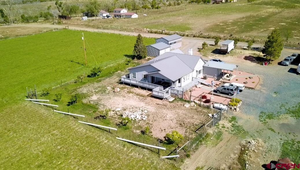 Outstanding panoramic views of the San Juan Mountain range, the Uncompaghre, the West Elk Wilderness, the Black Canyon of the Gunnison and the beautiful Grand Mesa from this lovingly remodeled spacious farmhouse, situated on 40+ Acres.  The home has new plumbing and electrical, central air & heating, with all new cabinetry in the beautiful kitchen with abundant countertop space.  There are several windows throughout the home to enjoy the stunning view from anywhere in the home, plus there is luxury plank vinyl flooring and solid core doors throughout.  Lovely living room is adjacent to the family room, great for entertaining.  The beautiful primary suite also has French doors leading onto the wrap-around deck to take in the views and enjoy the outdoors. The primary suite has a walk-in closet, soaker tub and a separate “rain can shower”.   In the past, the property has been used for raising livestock and producing hay.  Fertile pastures, barn, loafing shed, tack for horses, storage shed along with RV garage and a 2 car garage, all makes this wonderful acreage perfect for horses, a hobby farm, perfect for a vineyard or whatever your imagination brings.  There is also an irrigation pipe system designed for the 21 acres with irrigation water.