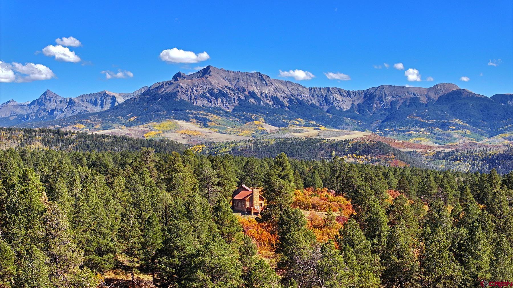 Wilson Bar Ranch encompasses 653± acres of diverse and scenic alpine terrain just 35 minutes from Telluride and Ridgway. The landscape features rolling hills and dense forests of aspen, ponderosa pine, and gamble oak, creating a rich and varied habitat. A large spring-fed pond enhances the natural setting, while stunning panoramic views of the Wilson and Sneffels Ranges define its mountain character. Protected by a canopy of old-growth ponderosas, a custom timber cabin offers an appealing respite for relaxing or entertaining. Located in a top-quality hunting unit, the ranch supports abundant wildlife populations. It offers excellent opportunities for hunting, riding, and year-round recreation, all within a picturesque setting that embodies the best of Colorado's high-country. It is rare to find over a square mile of improved recreational land with a location that is as close to the Telluride ski slopes, the new Four Seasons Resort, and the most attractive historic town in the entire region.