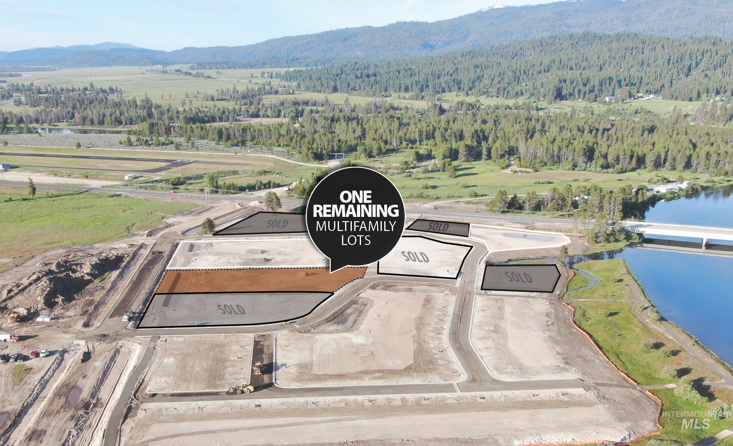 Aerial view of property and surrounding area with a forest and a water and mountain view